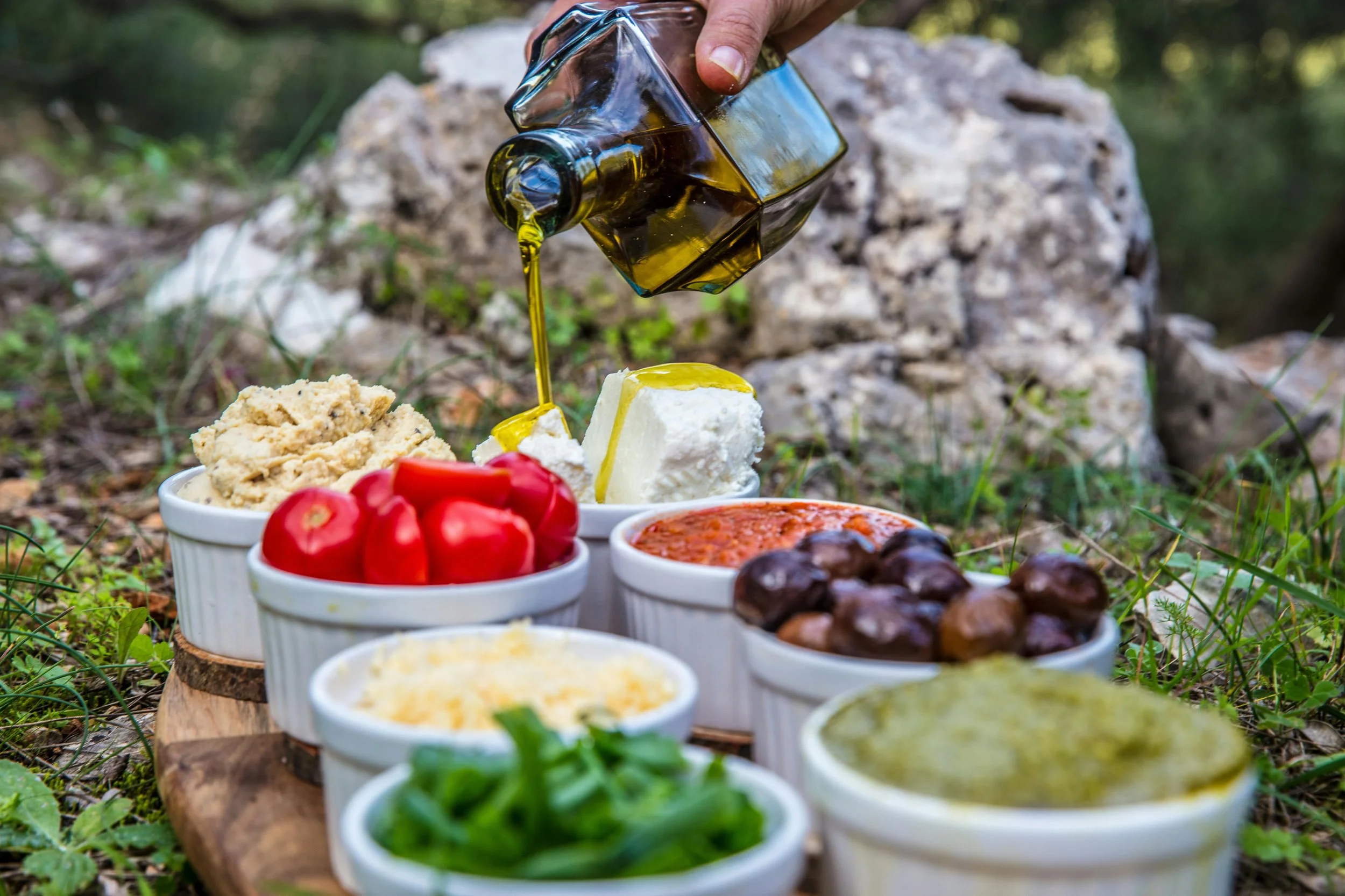 extra virgin olive oil pouring over cheese and olives showing quality and freshness