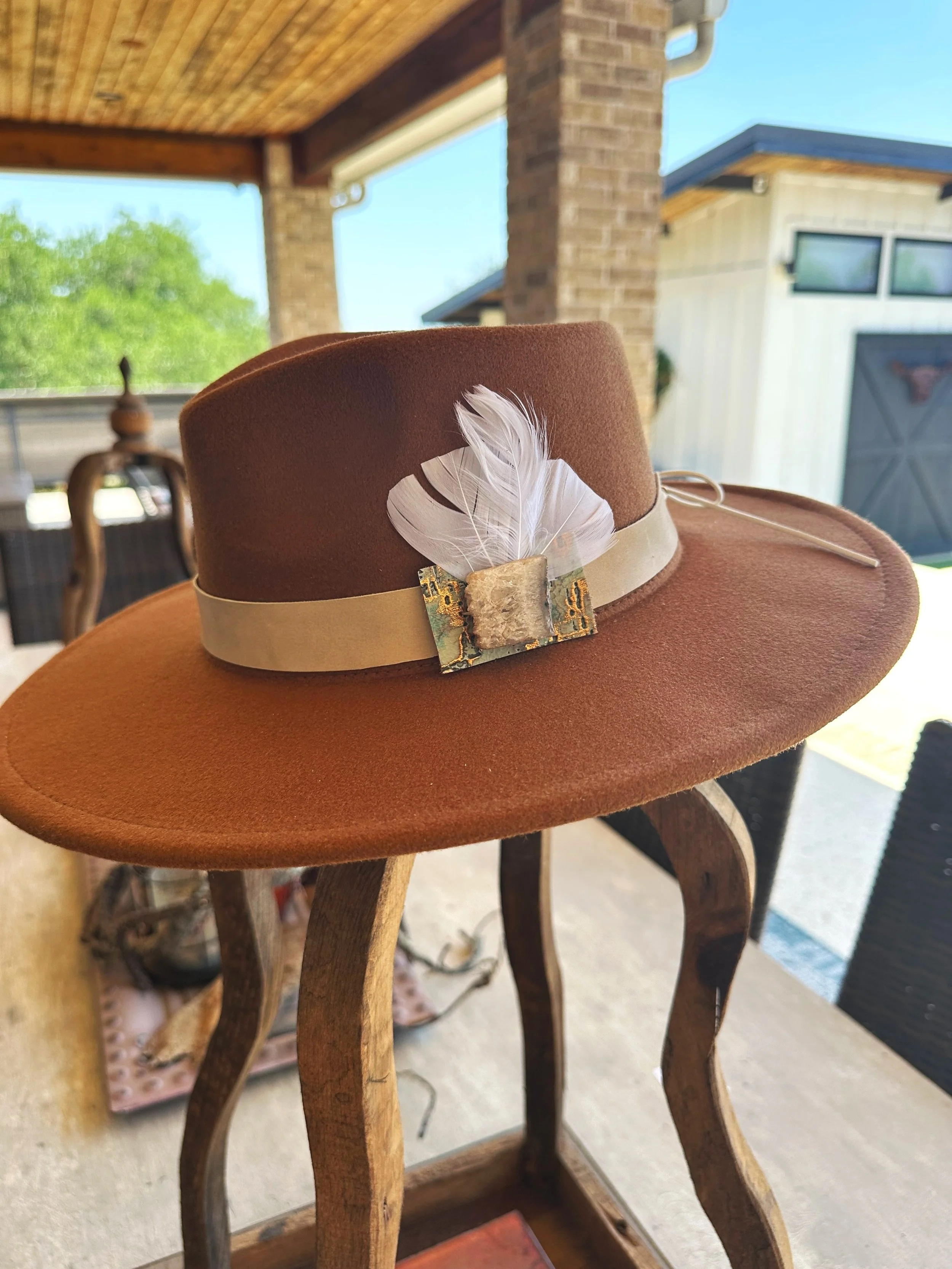 agate druzy stone on light colored calfskin band with white feather on carmel colored hat