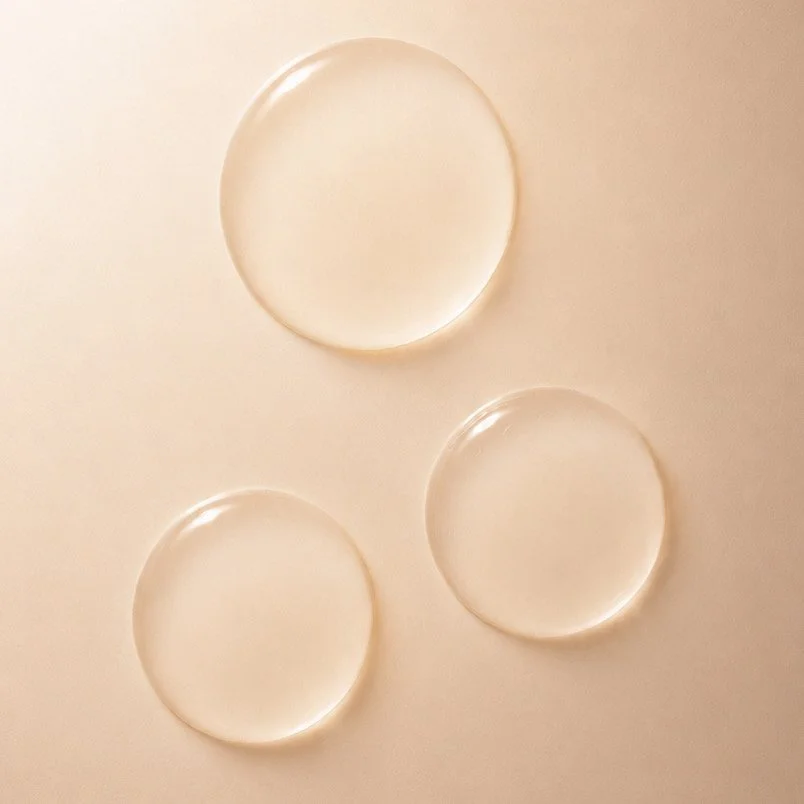 Three transparent glass petri dishes placed on a beige surface.