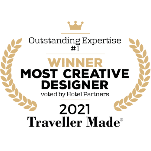Award badge with a crown and laurel branches, reading "Outstanding Experience Winner" for Most Creative Designer 2021, presented by Traveler Made.