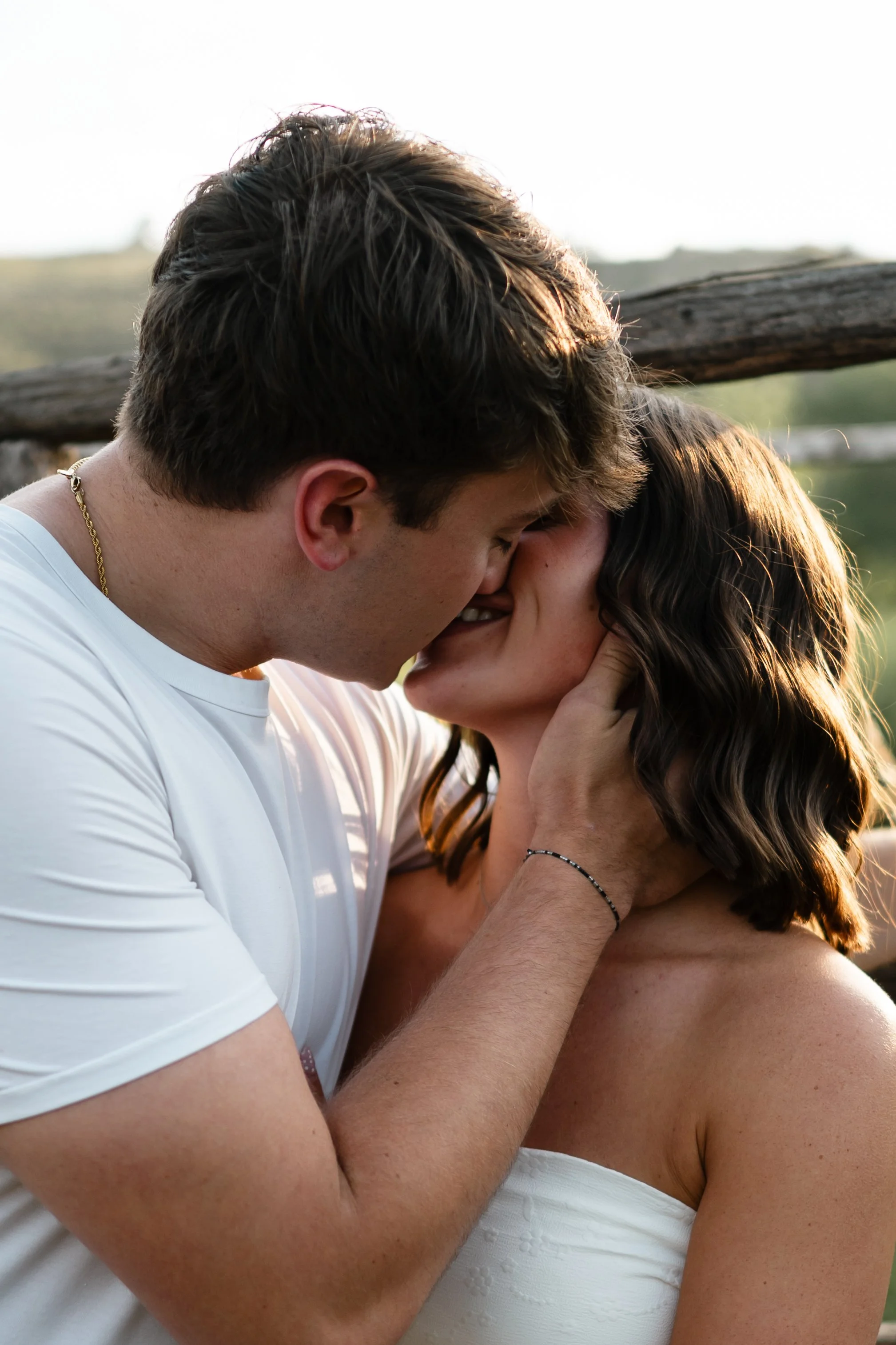 An engaged couple embracing in front of a western background in the mountains of Fort Collins Colorado at Horsetooth.