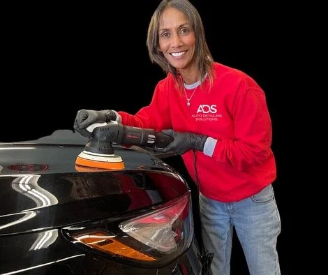 Person using a car polisher on a vehicle