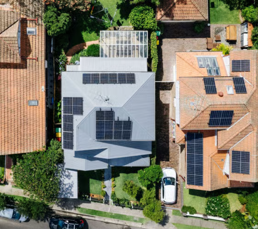 Two neighboring houses with rooftop solar panels.