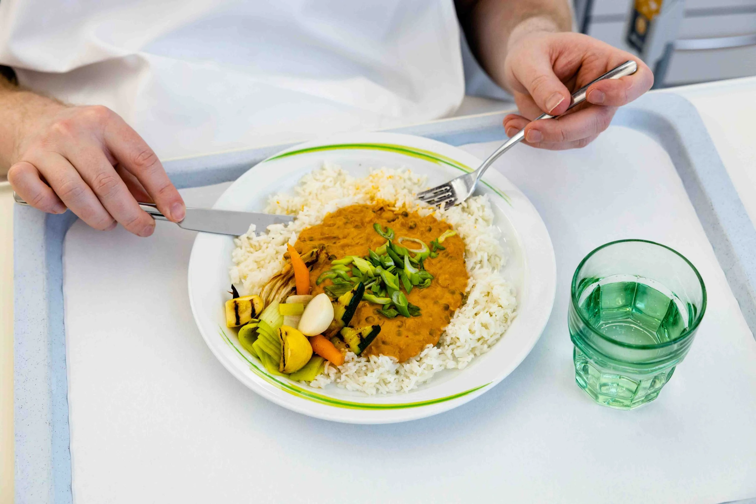 Gesunde Krankenhausverpflegung: Teller mit Reis, Gemüse und Currysauce wird gegessen – Healthy Hospital Food