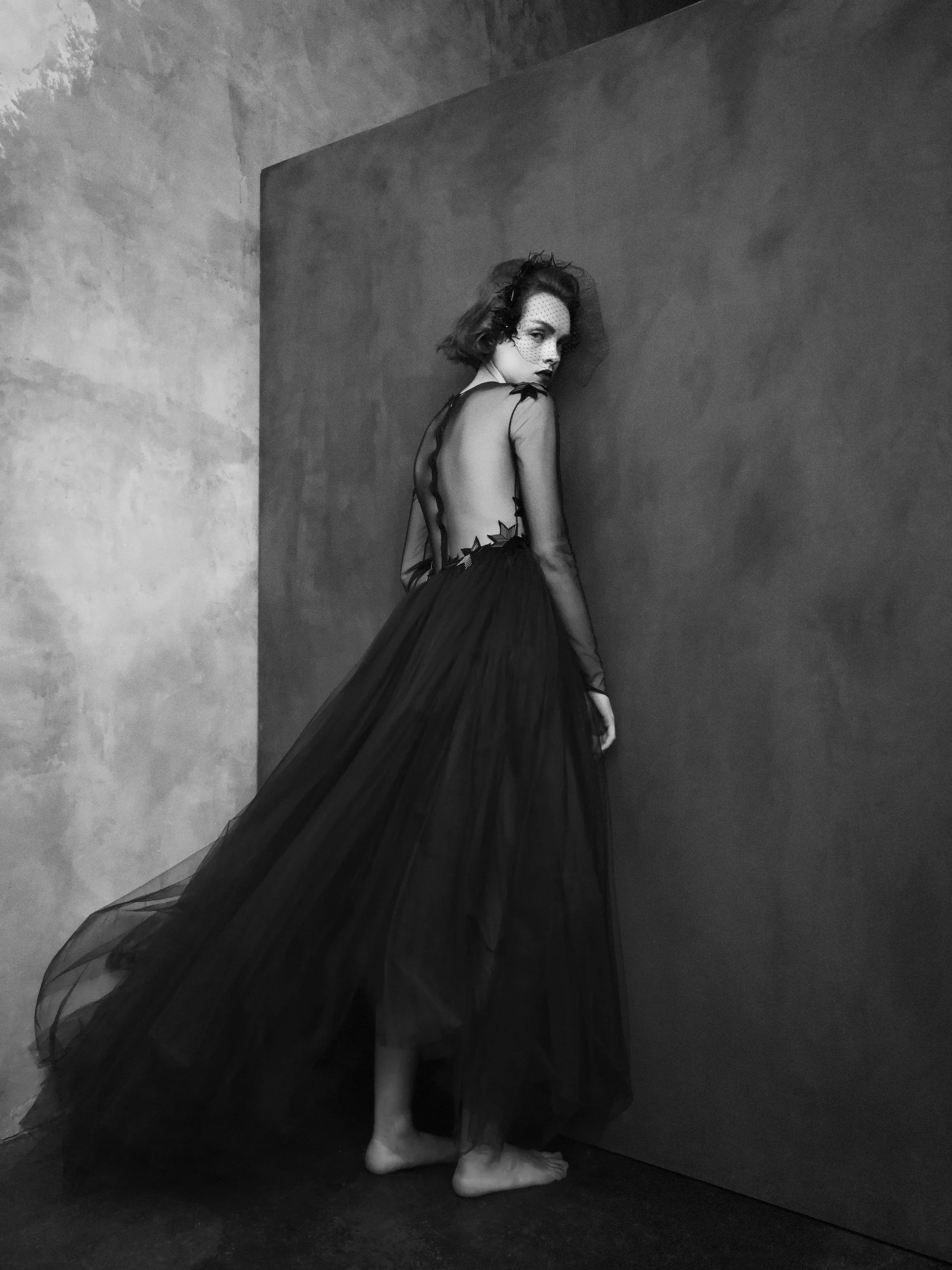 Schwarzweiß-Porträt eines Models vor Betonwand in Couture-Roben, fotografiert mit Huawei Pro Plus, produziert von imagespy für VOGUE-Advertorial.