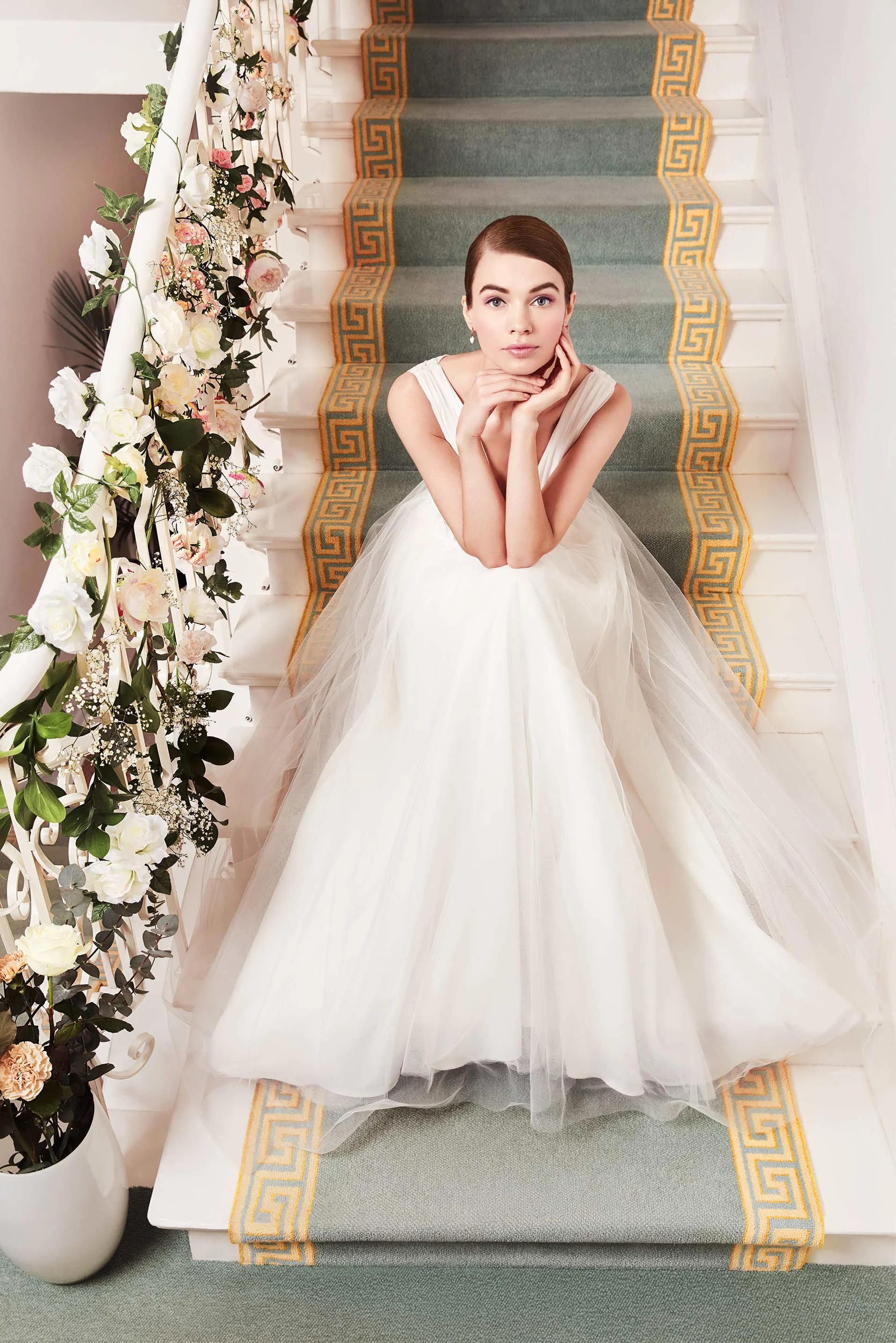 C&A Wedding Special 2019: Braut im märchenhaften Tüllkleid sitzt auf blumengeschmückter Treppe – hochwertige Editorial-Inszenierung von imagespy für Modejournalisten und Presse.