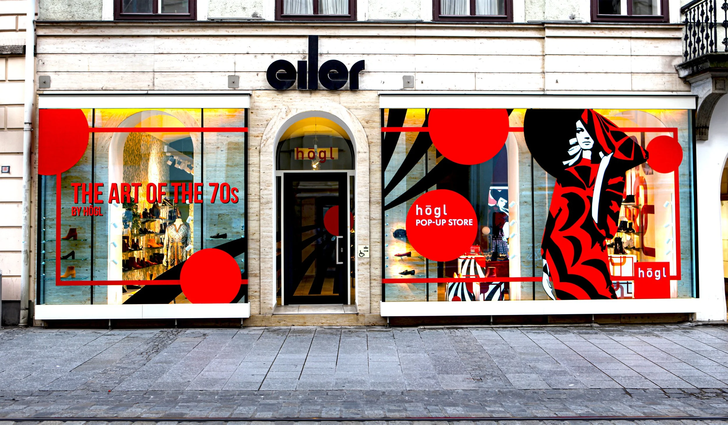 Außenansicht des Högl Pop-up Stores bei Eiler mit Schaufenstergestaltung im „The Art of the 70s“ Stil.