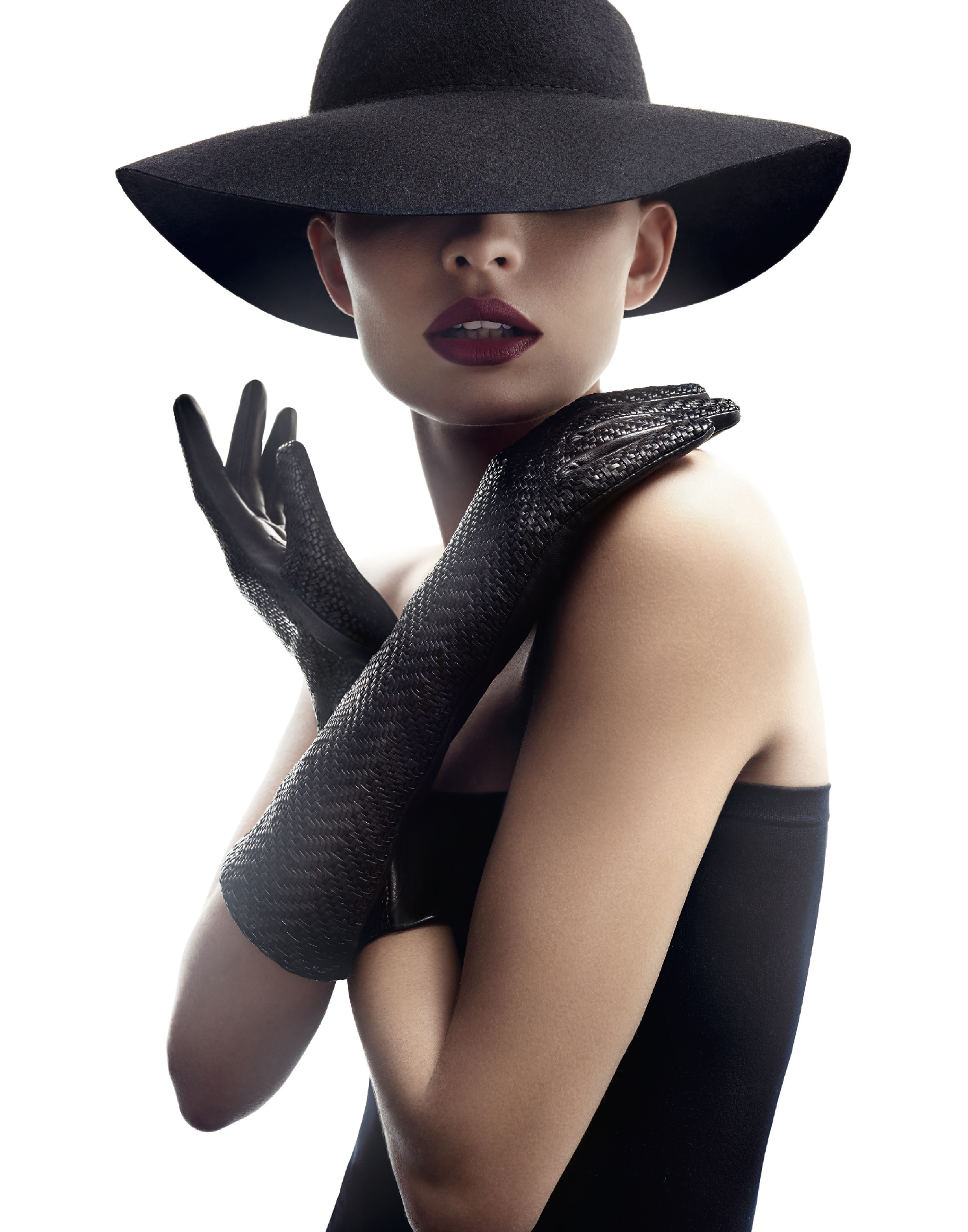 Minimalistische Aufnahme einer Frau im schwarzen Kleid mit Hut und Lederhandschuhen aus der Roeckl Fall/Winter 2017 Kollektion, umgesetzt von imagespy.