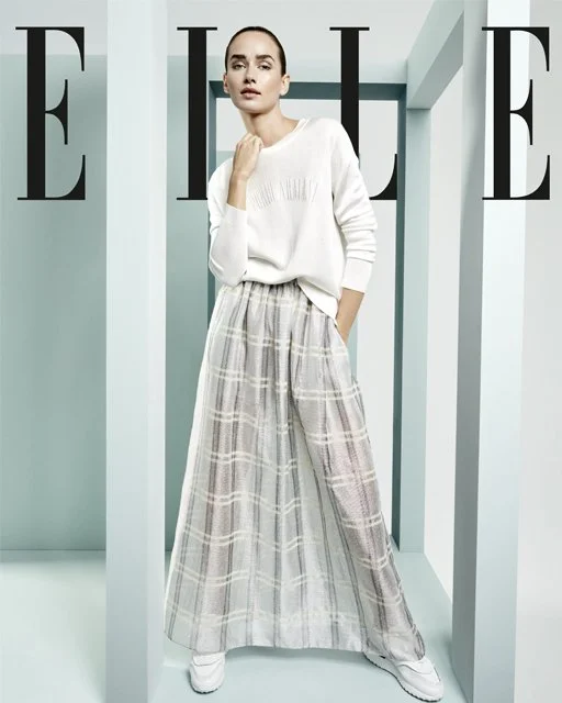 Studioaufnahme 2019 für Lodenfrey in ELLE: Model im Mix-&-Match-Look aus Rock und Pullover von Armani mit weißen Sneakern von Tod’s, High-End-Fashion mit moderner Leichtigkeit, inszeniert von imagespy.