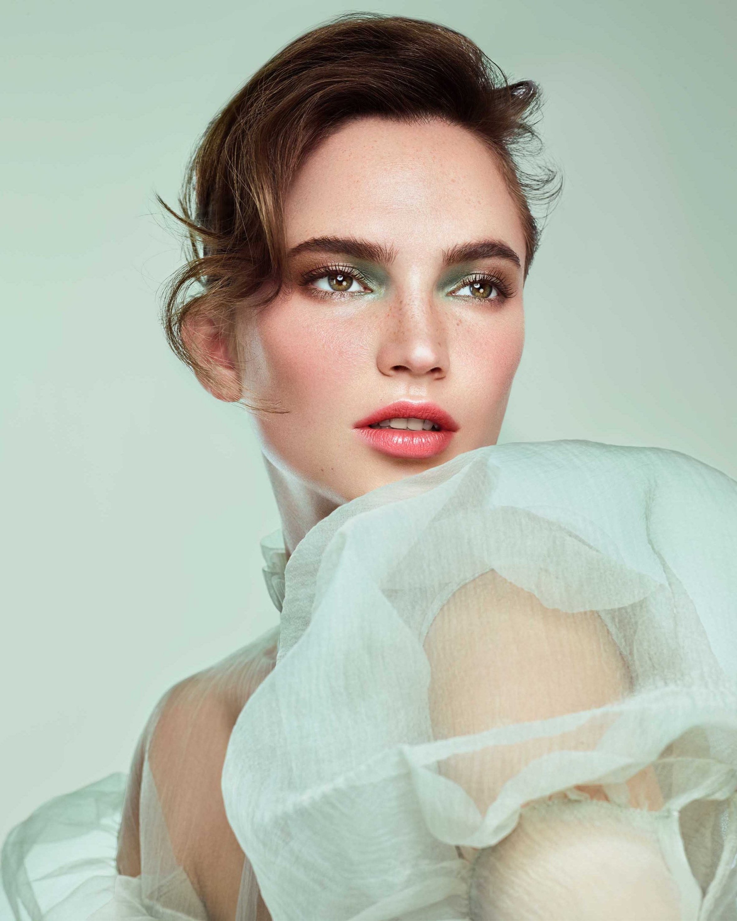 Portrait einer Frau vor mintfarbenem Hintergrund mit türkisfarbenem Lidschatten und elegantem Kleid, Kampagnenvisual für Makeup Factory, umgesetzt von imagespy.