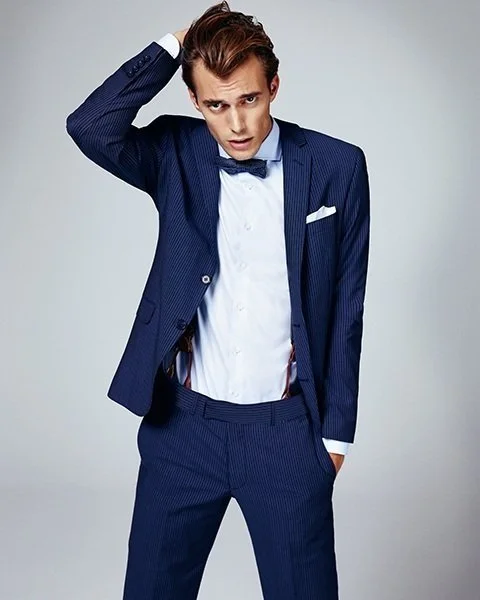 GQ Promotion by imagespy: Male Model in dunkelblauem Anzug greift sich in die Haare, stilvolle Studioaufnahme für SIR OLIVER.