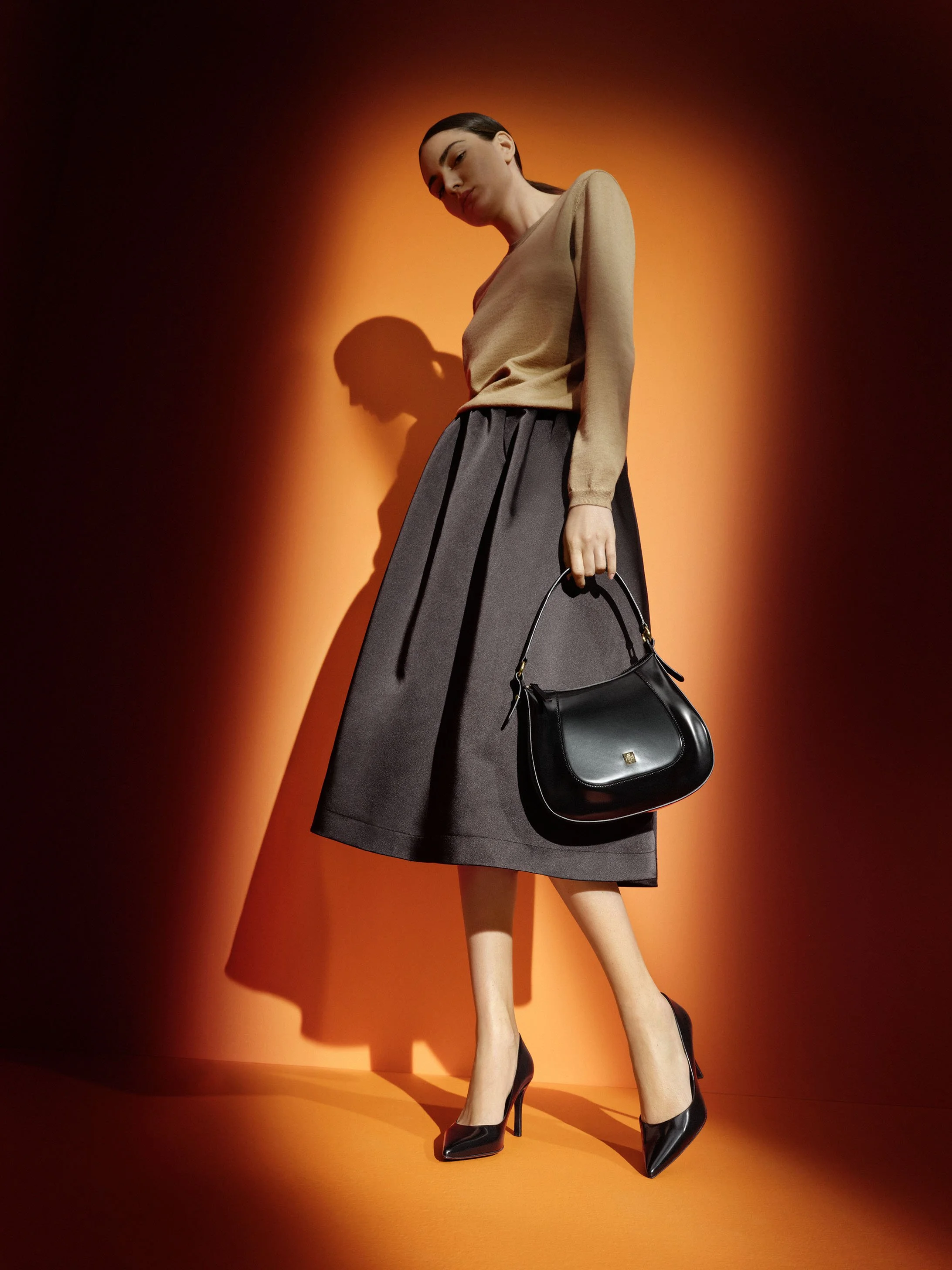 Model in Pullover-Rock-Kombi mit schwarzen Högl Stiletto-Pumps „Boulevard 70“ und Tasche „Abbie“, Studioaufnahme F/W 2023 von imagespy.