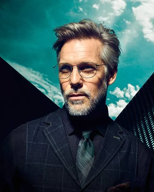 Mann im Anzug mit Rodenstock Brille Mega-Slim-Fassung vor blauem, wolkigem Himmel, Visual 2019 von imagespy.