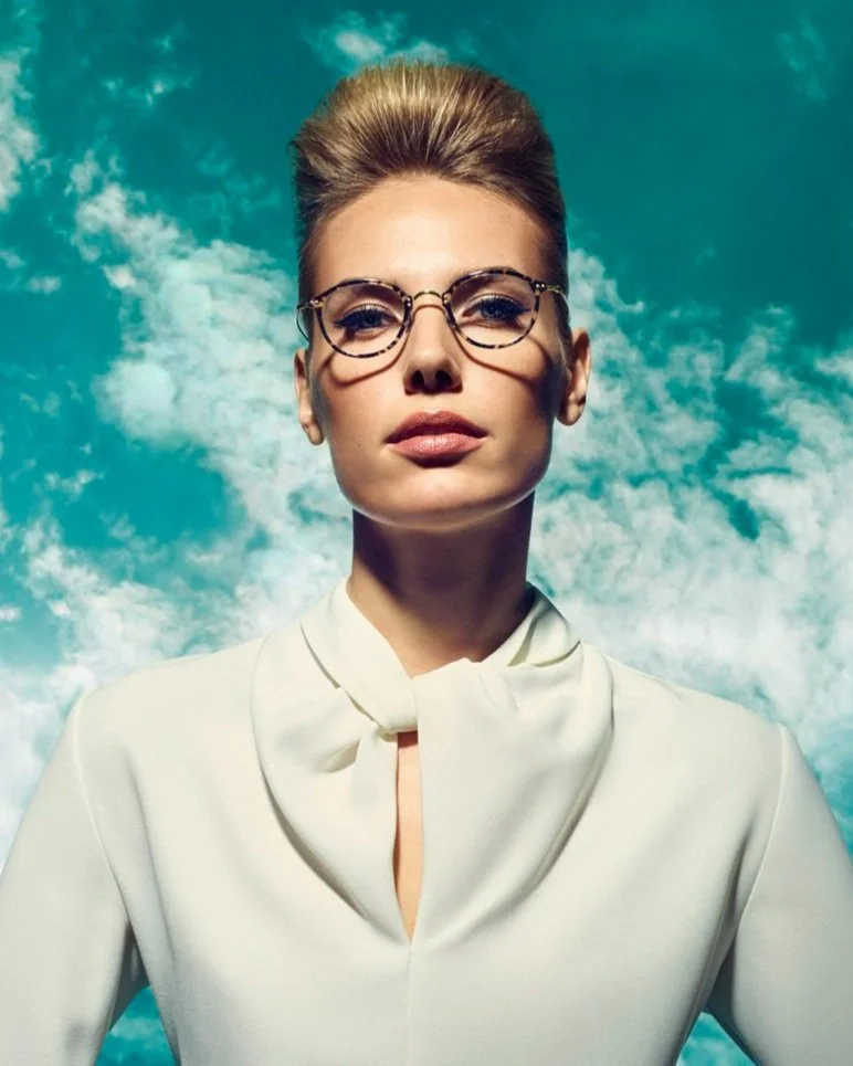 Frau in weißem Shirt mit Rodenstock Brille aus der Retro Classic Kollektion vor wolkigem Himmel, umgesetzt von imagespy.