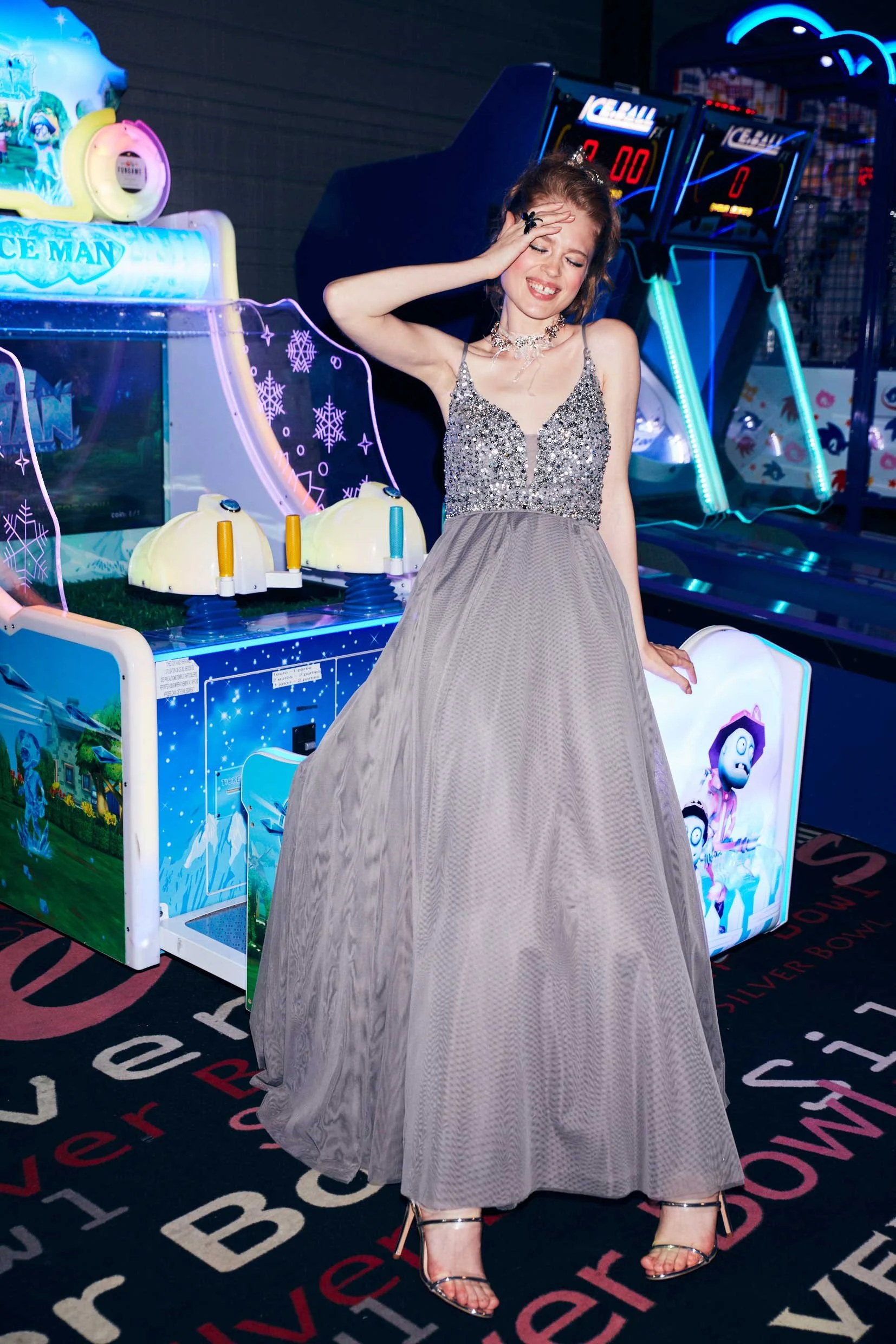 Model im nudefarbenen Glitzer-Tüllkleid lehnt an Spielautomaten, Game On Motiv von imagespy