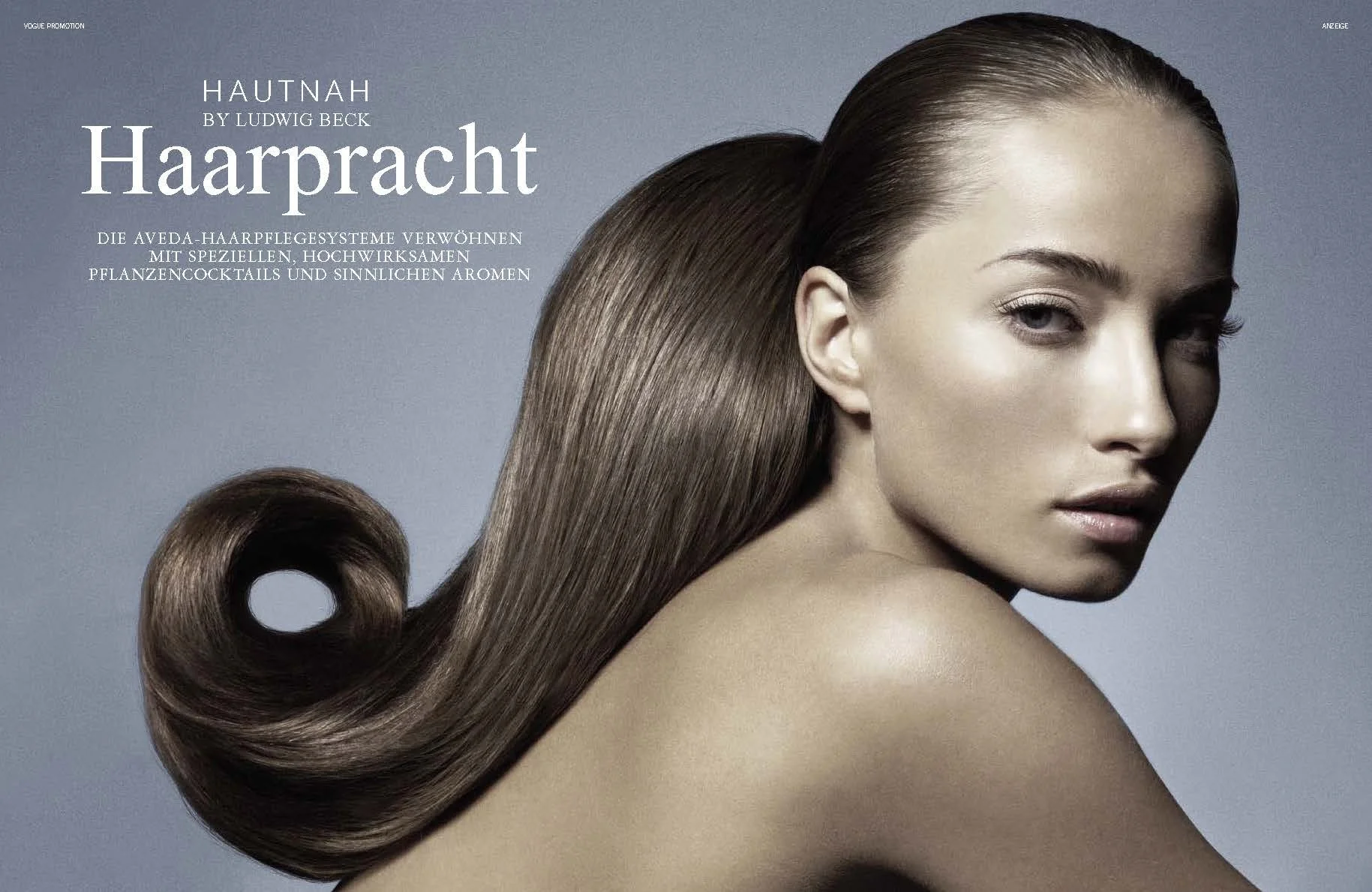 VOGUE Beauty Editorial Haarpracht by Ludwig Beck, umgesetzt von imagespy, künstlerisches Hair-Styling mit skulpturaler Locke und glänzender Textur vor grauem Hintergrund.