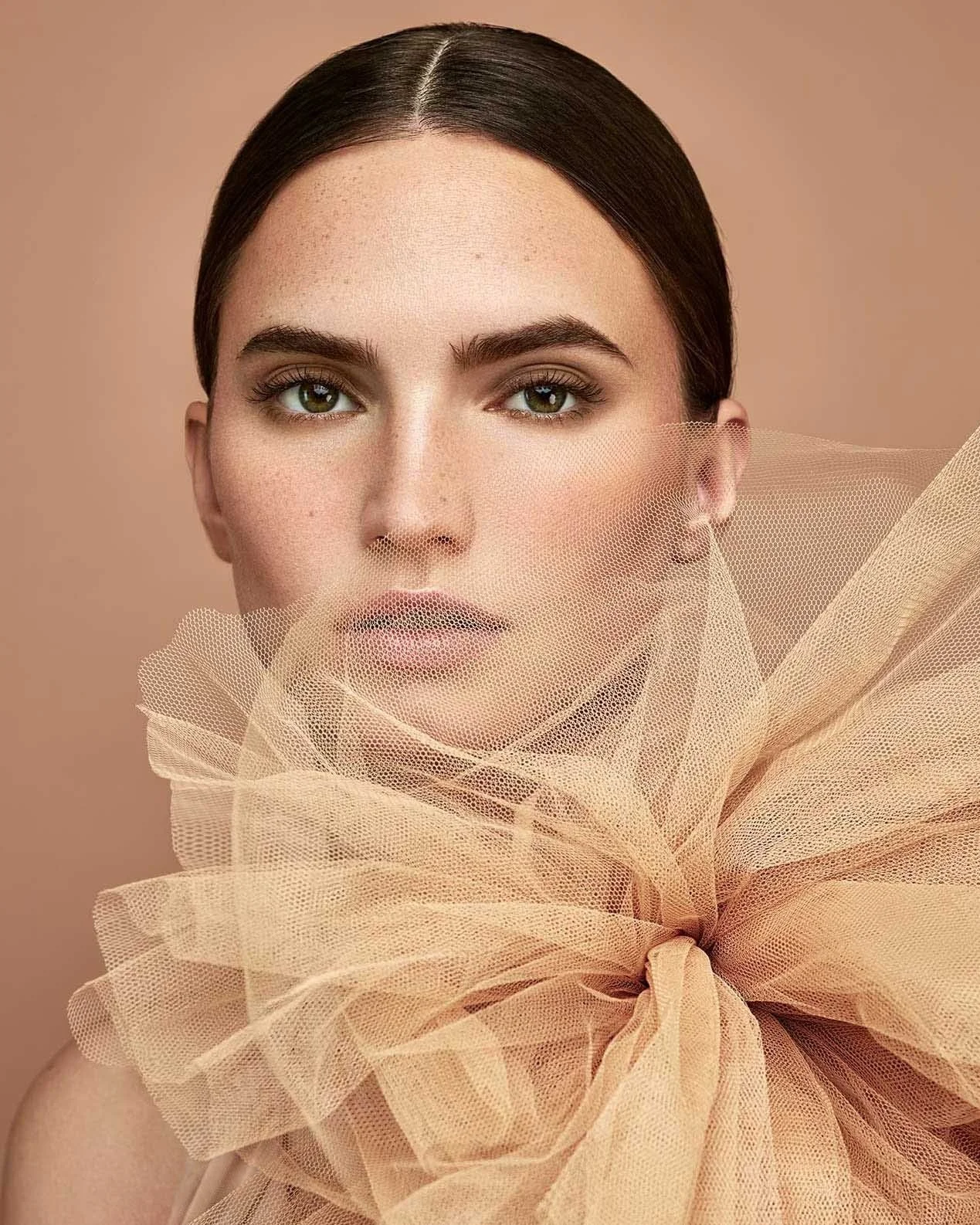 Frau im Tüllkleid mit großer Tüllblume und natürlichem Nude-Make-up-Look mit braunem Lidschatten, Kampagnenvisual für Makeup Factory, umgesetzt von imagespy.