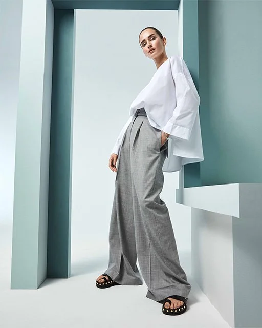 Studioaufnahme 2019 für Lodenfrey in ELLE: Model in grauer Anzughose und weißer Bluse von Larens, urbaner Nomadenchic in luxuriöser High-End-Fashion-Inszenierung von imagespy.