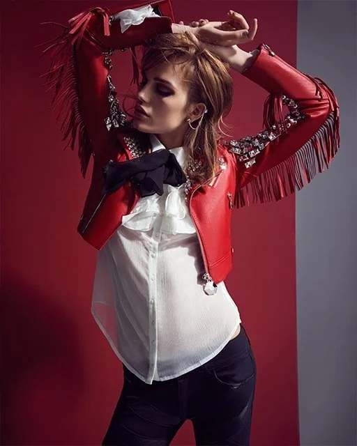 Model posiert für McArthurGlen/GLAMOUR in roter Lederjacke und -hose von Philipp Plein, Rüschenbluse von Anne Fontaine, Ohrringe von Atelier Swarovski by Jean Paul Gaultier – glamouröse High-End-Fashion-Fotografie von imagespy.