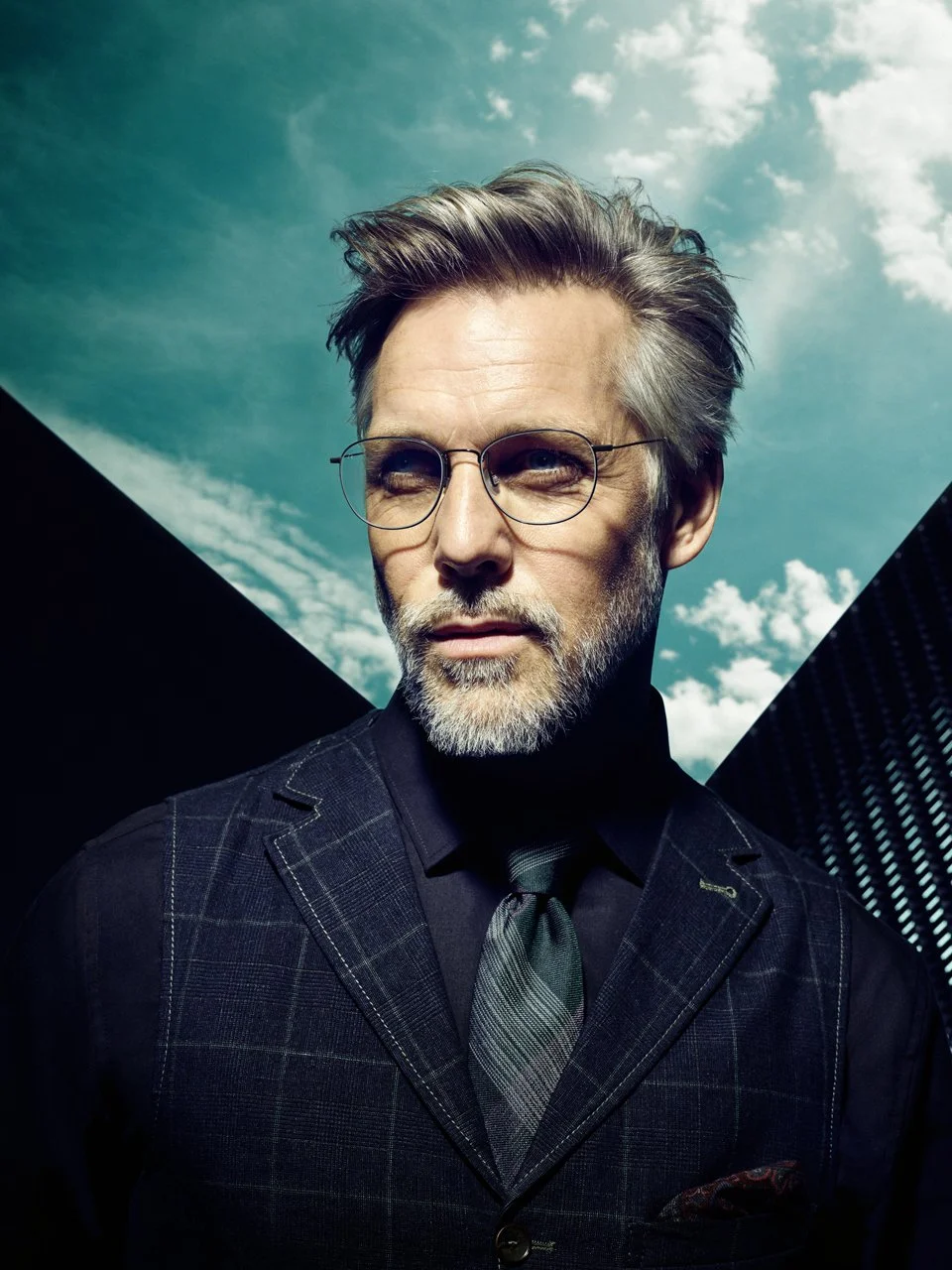 Mann im Anzug mit Rodenstock Brille Mega-Slim-Fassung vor blauem, wolkigem Himmel, Visual 2019 von imagespy.