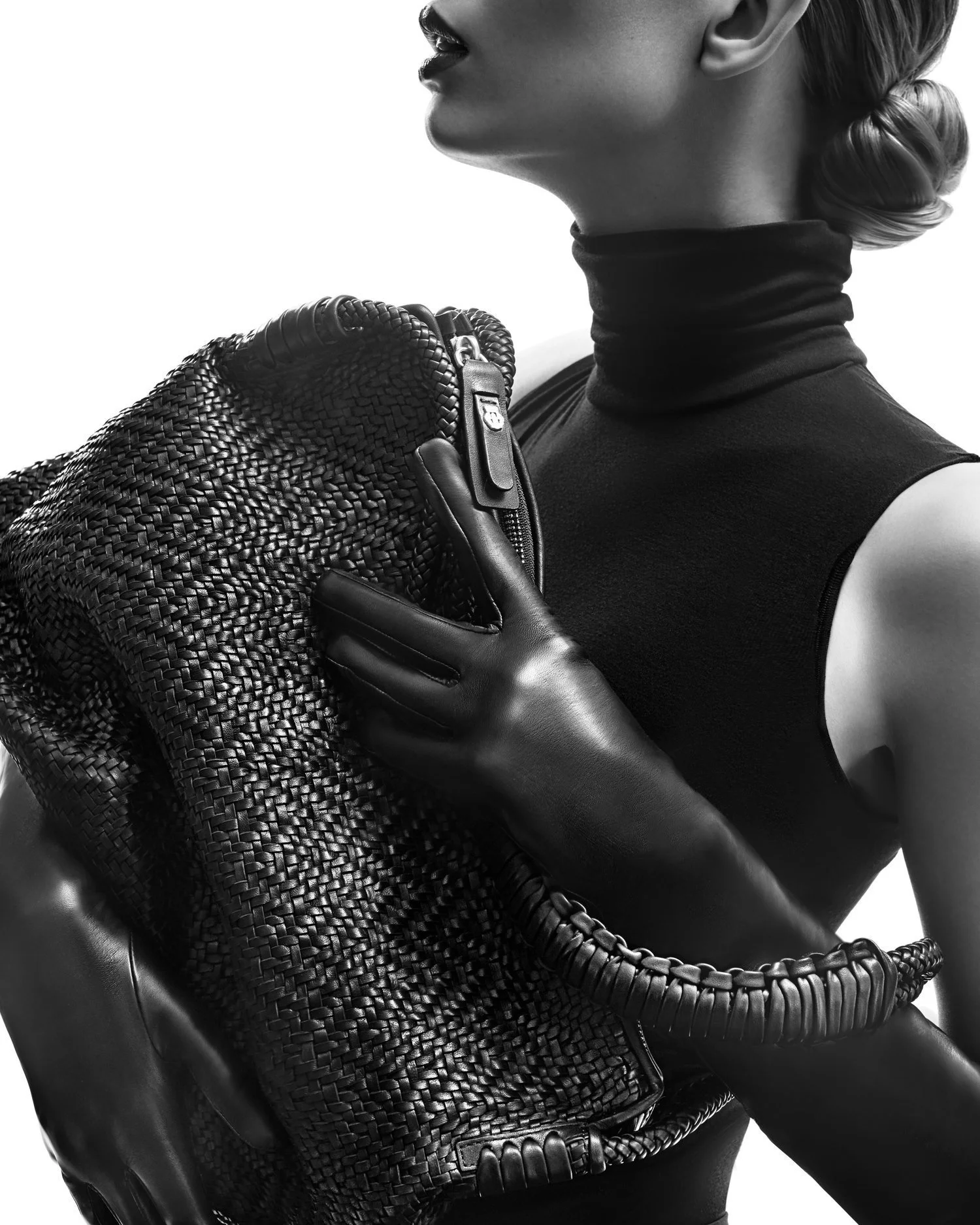 Frau im schwarzen Rollkragen-Top mit Lederhandschuhen und geflochtener Tasche aus der Roeckl Fall/Winter 2017 Kollektion, inszeniert von imagespy.