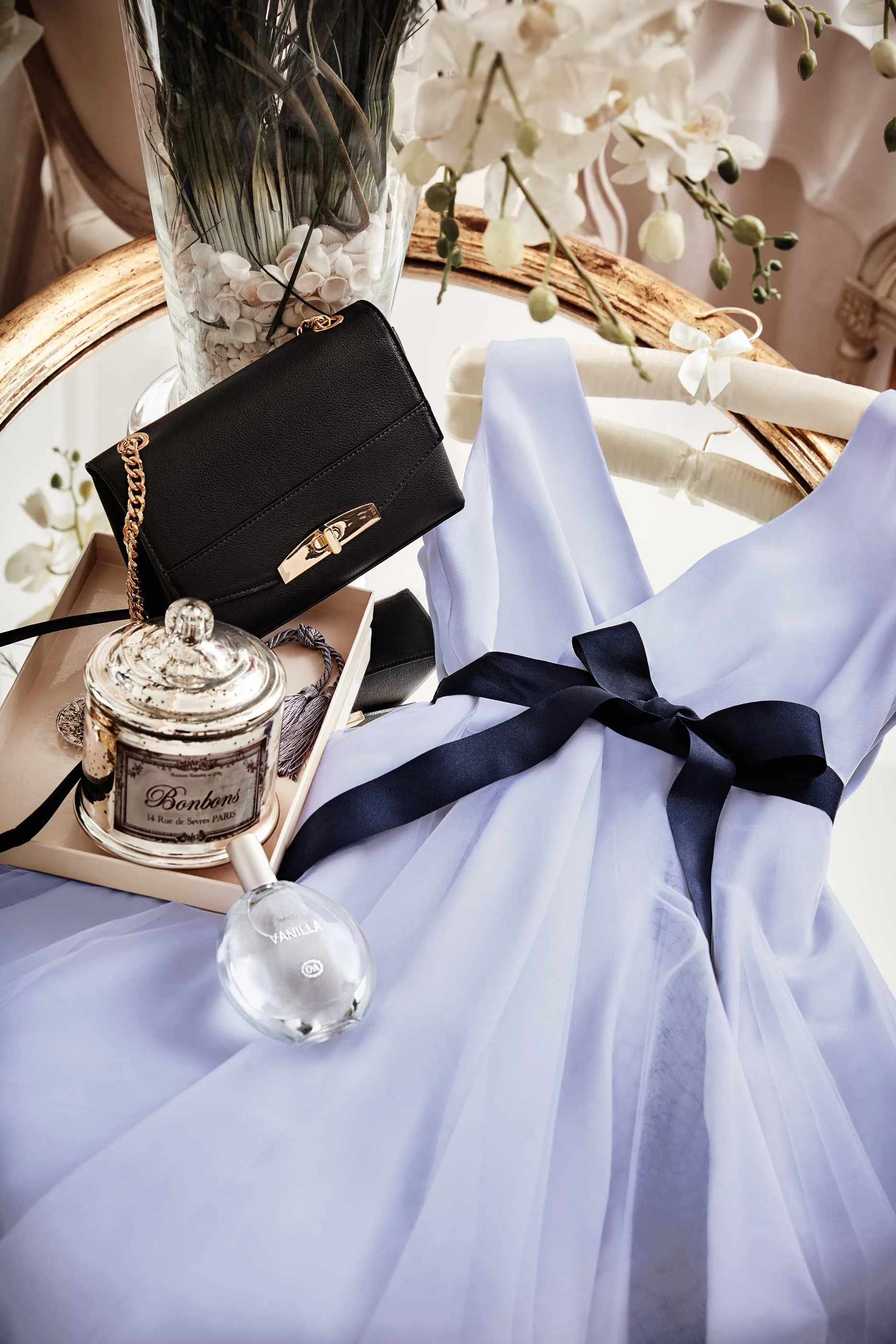 C&A Wedding Special 2019: Fliederfarbenes Bridesmaid-Kleid auf Spiegel mit Goldrahmen, schwarze Clutch – romantische Editorial-Inszenierung von imagespy für Modejournalisten