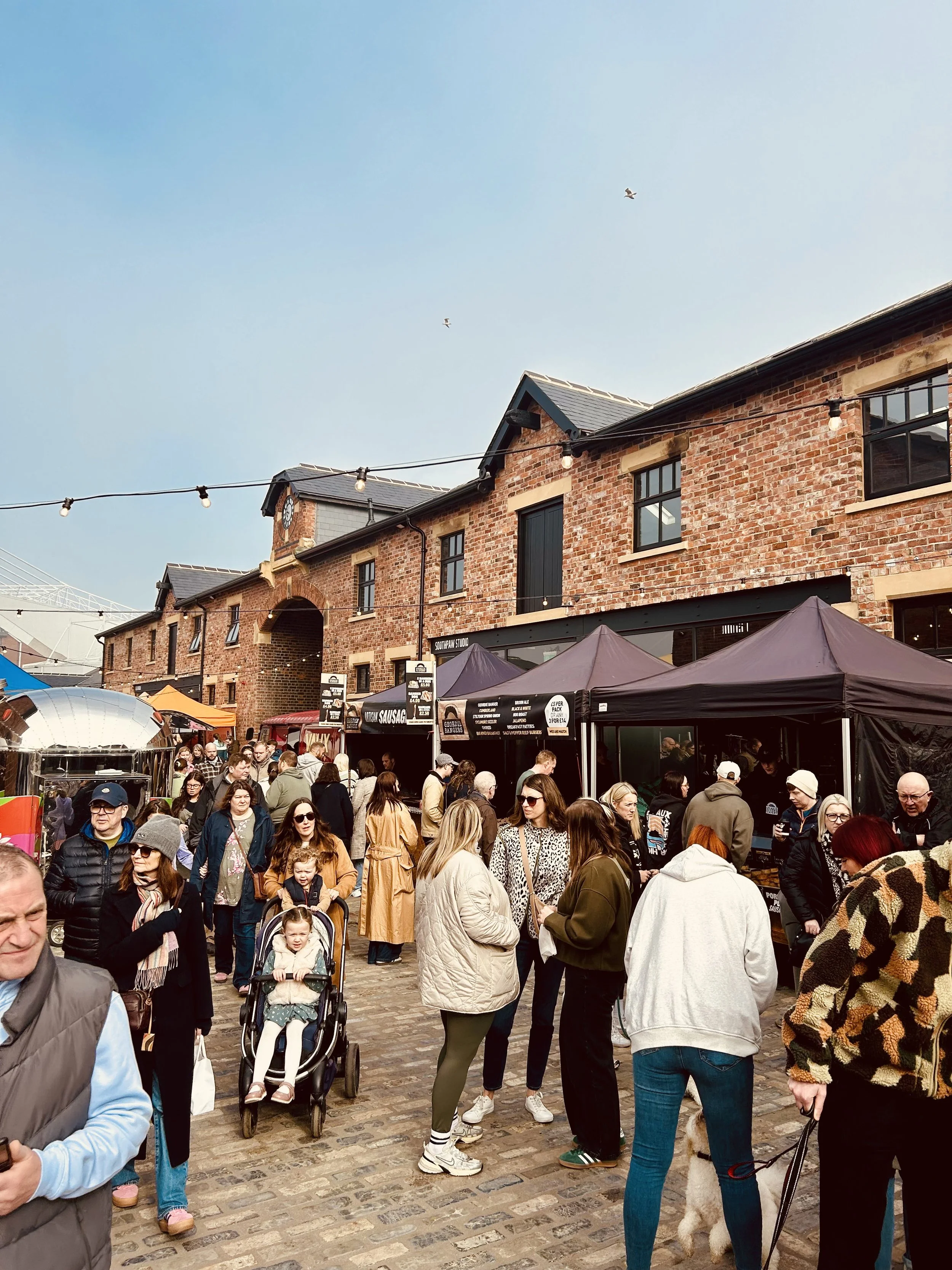Market stalls and people walking around at Sheepfolds Stables in Sunderland
