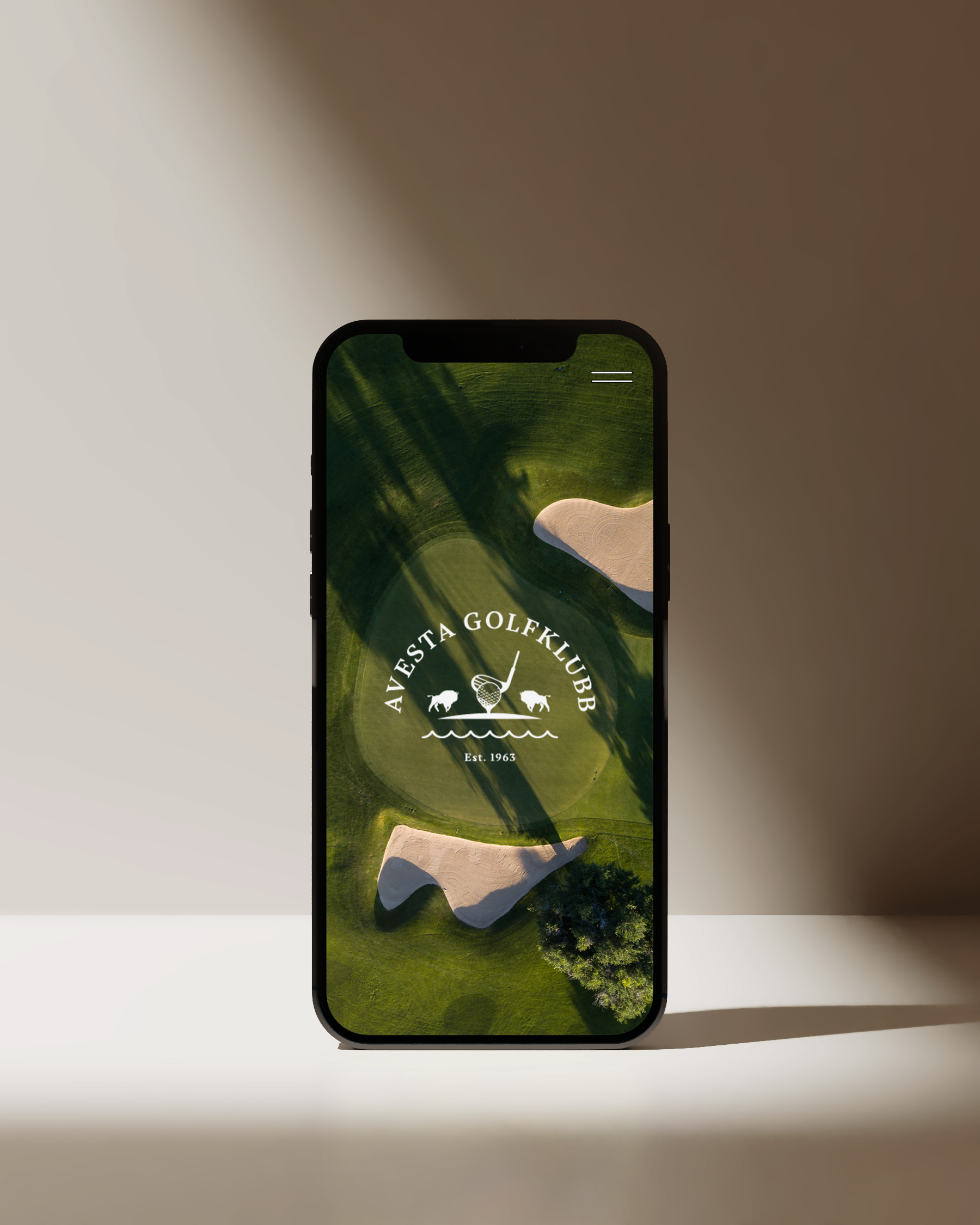 En mobiltelefon som visar en golfklubb med en golfbana och klubbens logo.