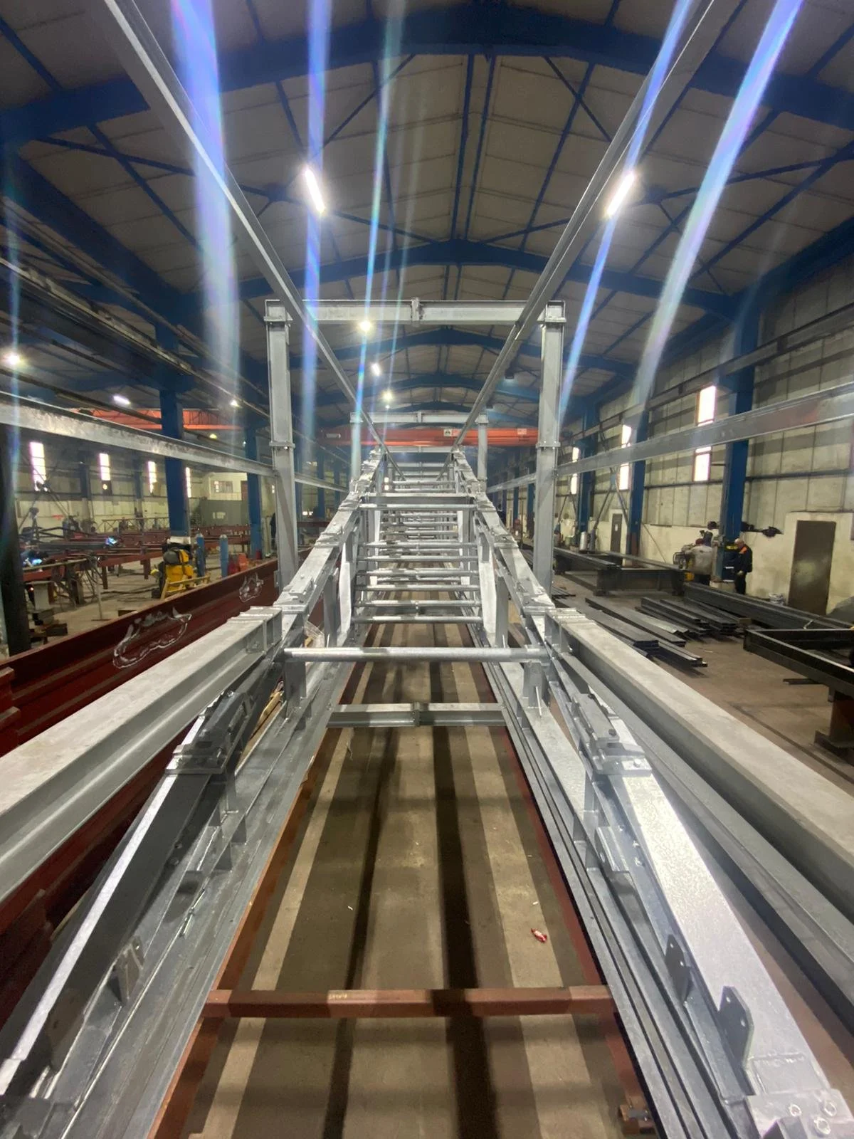 Interior of an industrial facility with steel beams and framework, under construction.