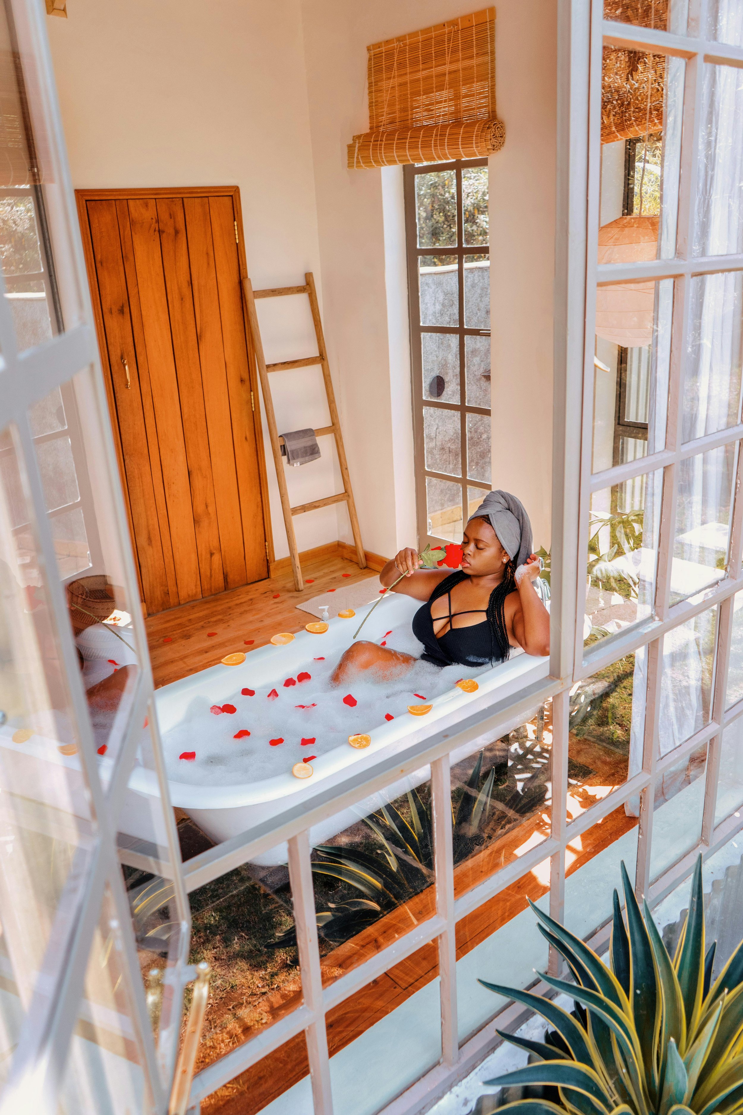 Femme afro dans un bain spirituel avec herbes et bougie – rituel de purification