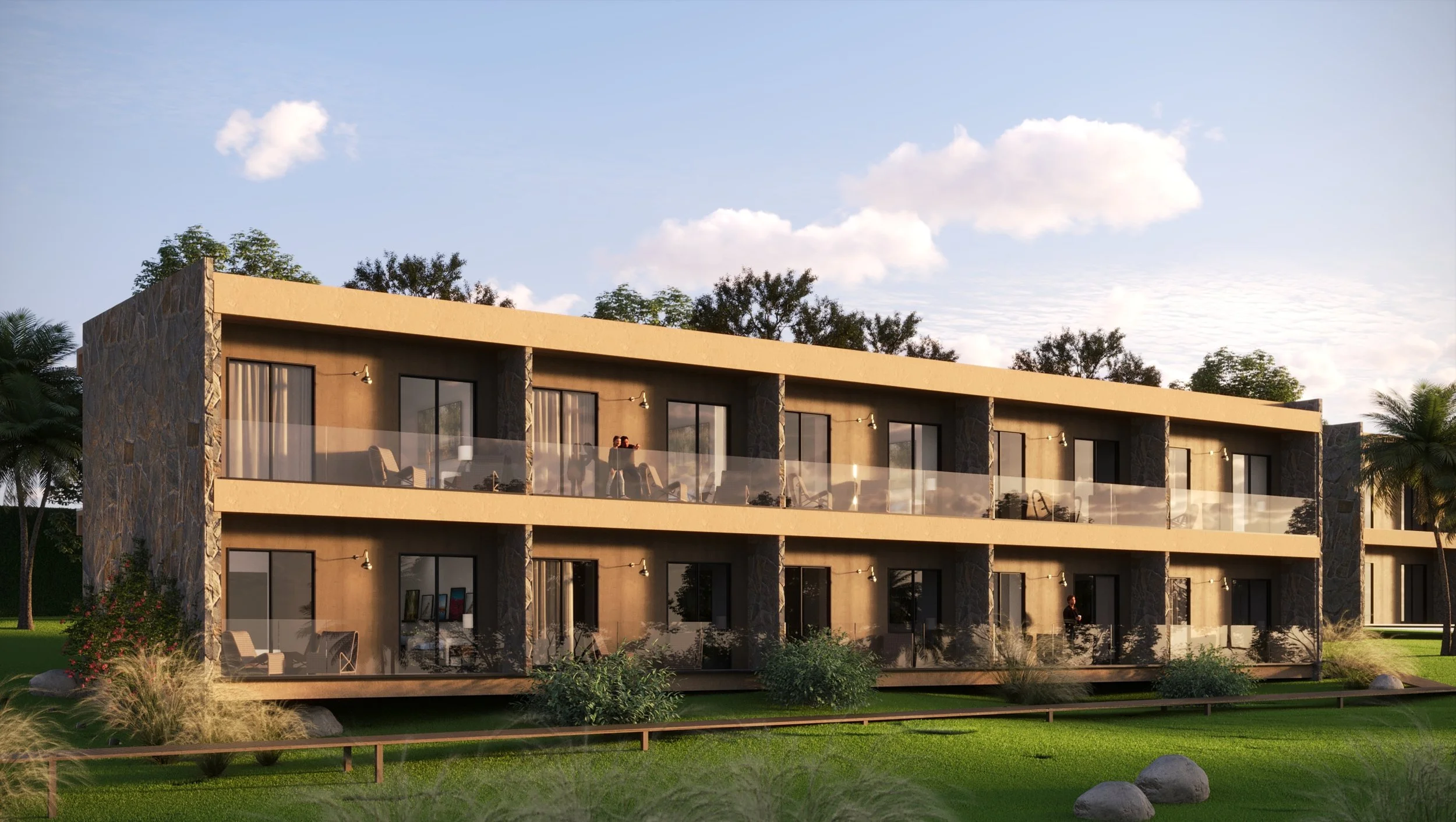 Modern two-story apartment building with balconies and glass railings, surrounded by green grass, trees, and rocks, under a blue sky with clouds.