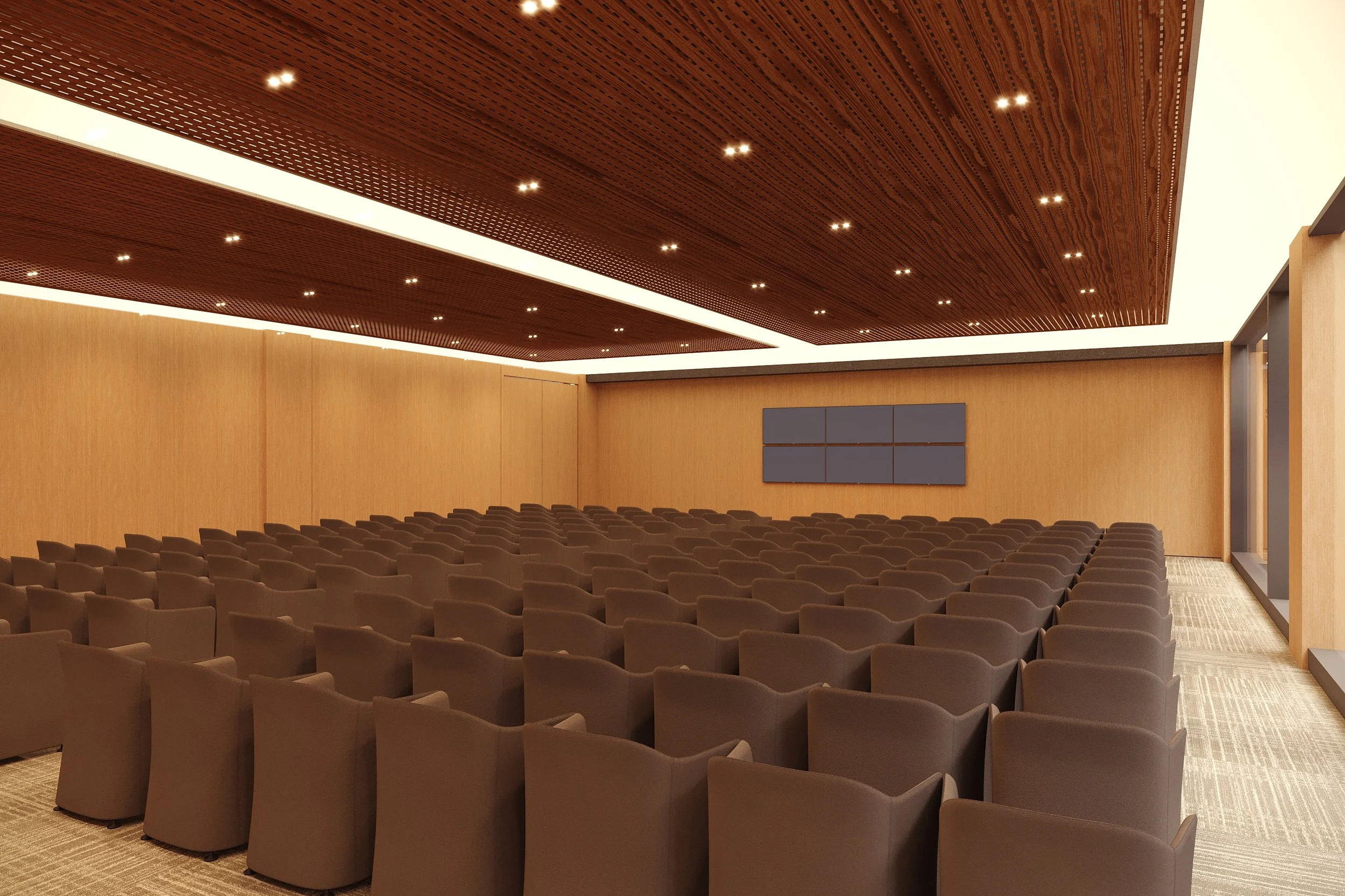 Empty conference room with brown chairs arranged in rows, wooden walls, ceiling with small lights, and multiple blue screens on the front wall.