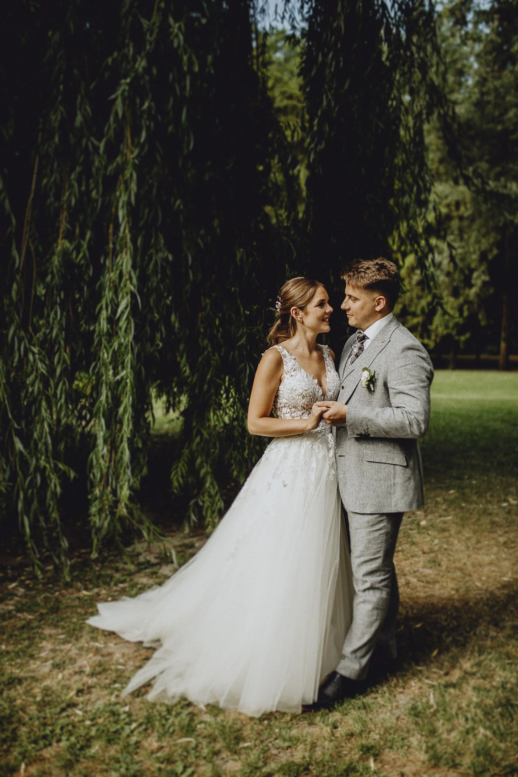Ein Brautpaar tanzt im Freien unter einem Baum bei einer Hochzeit.
