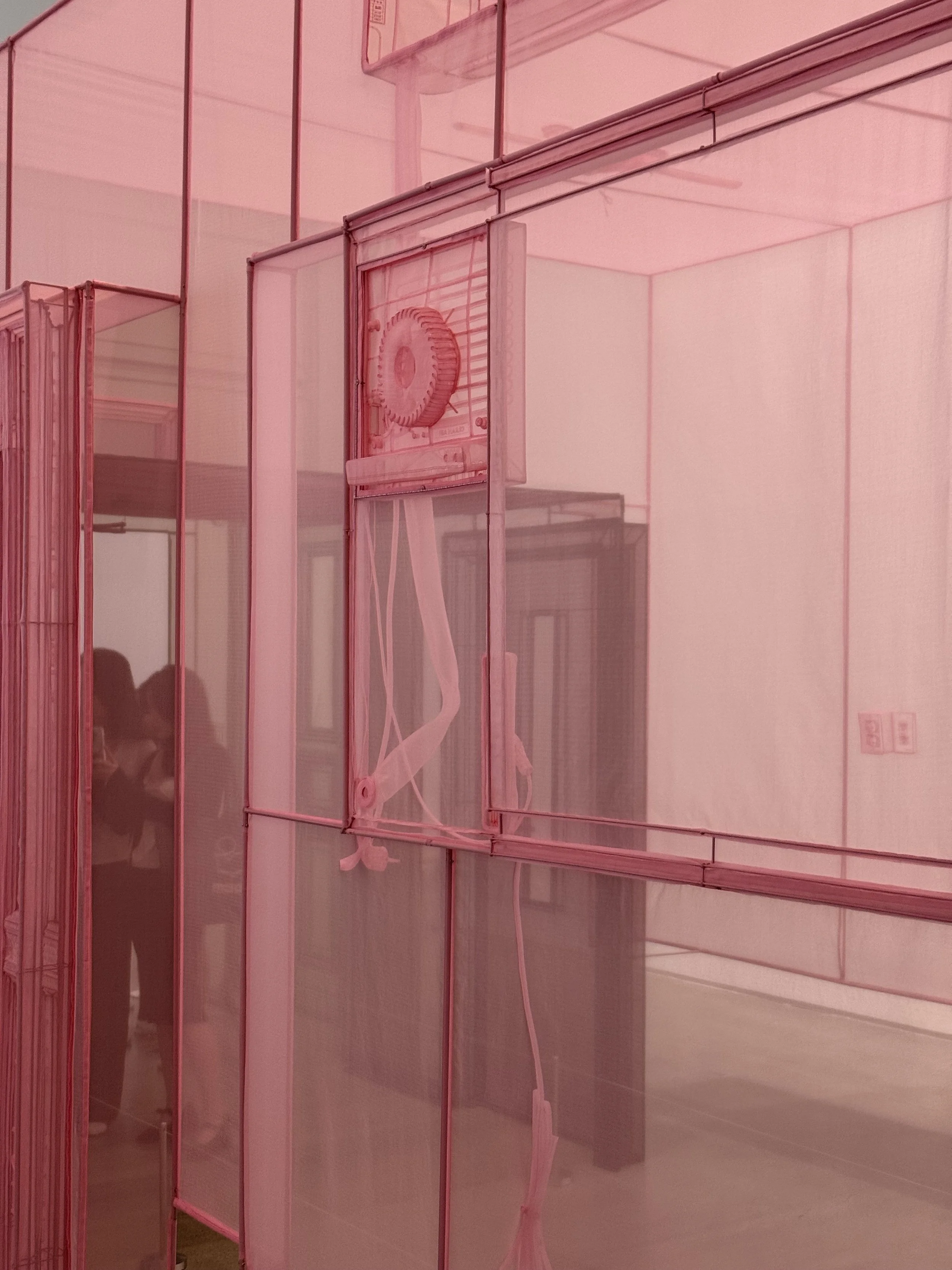 Close-up of Do Ho Suh’s translucent pink fabric architecture, showing a stitched window frame and layered interior structure at MMCA Seoul.
