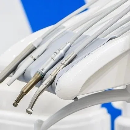 Dental handpieces and connectors on a tray with a blue and white background.