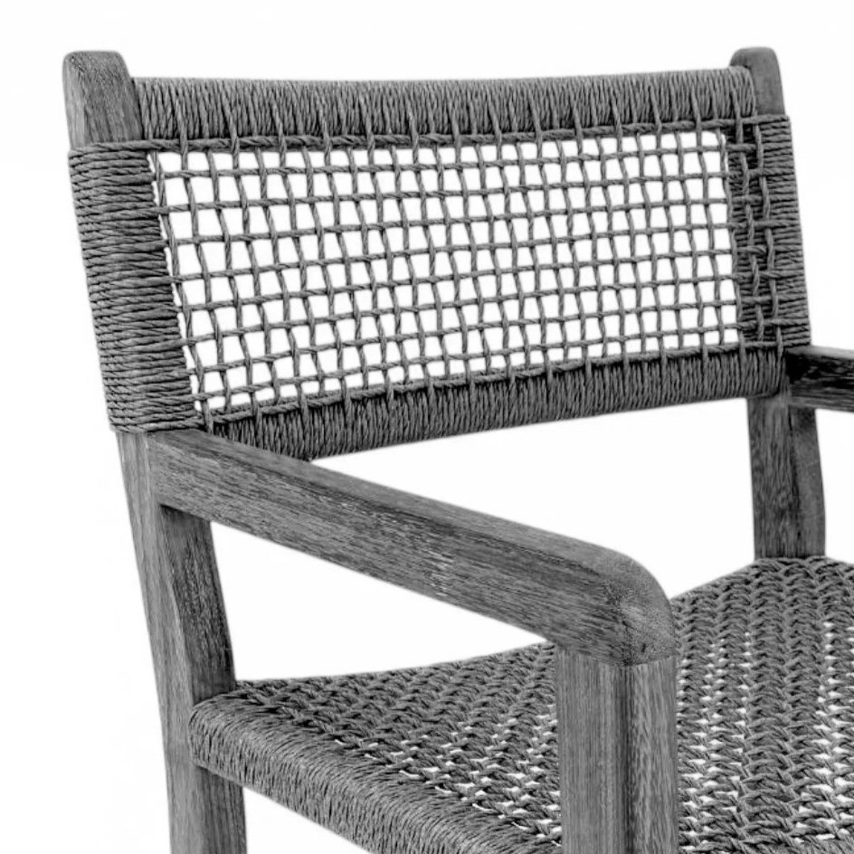 Close-up of a wooden chair with woven or rattan backrest and seat, in black and white.