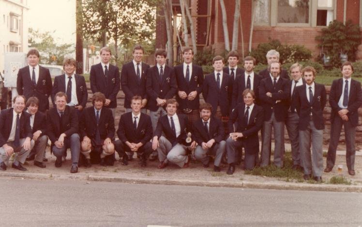 Group photo of men in suits outside a building