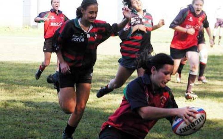 Women's rugby match with player scoring try
