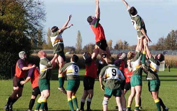 Rugby lineout with players jumping and reaching for ball