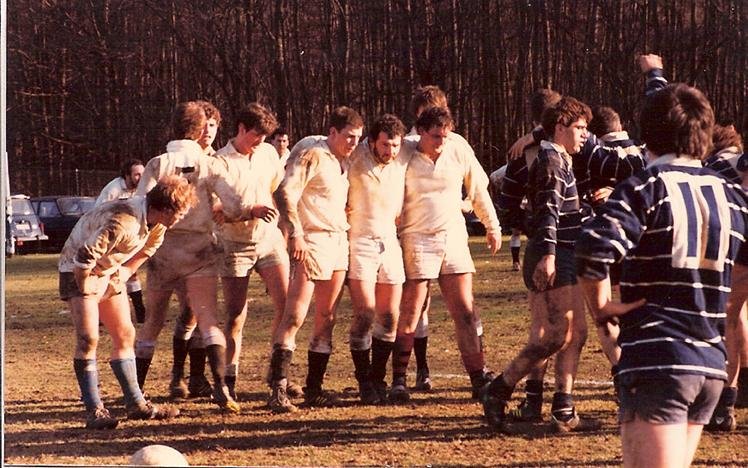Rugby players preparing for a scrum on a grassy field during a match.