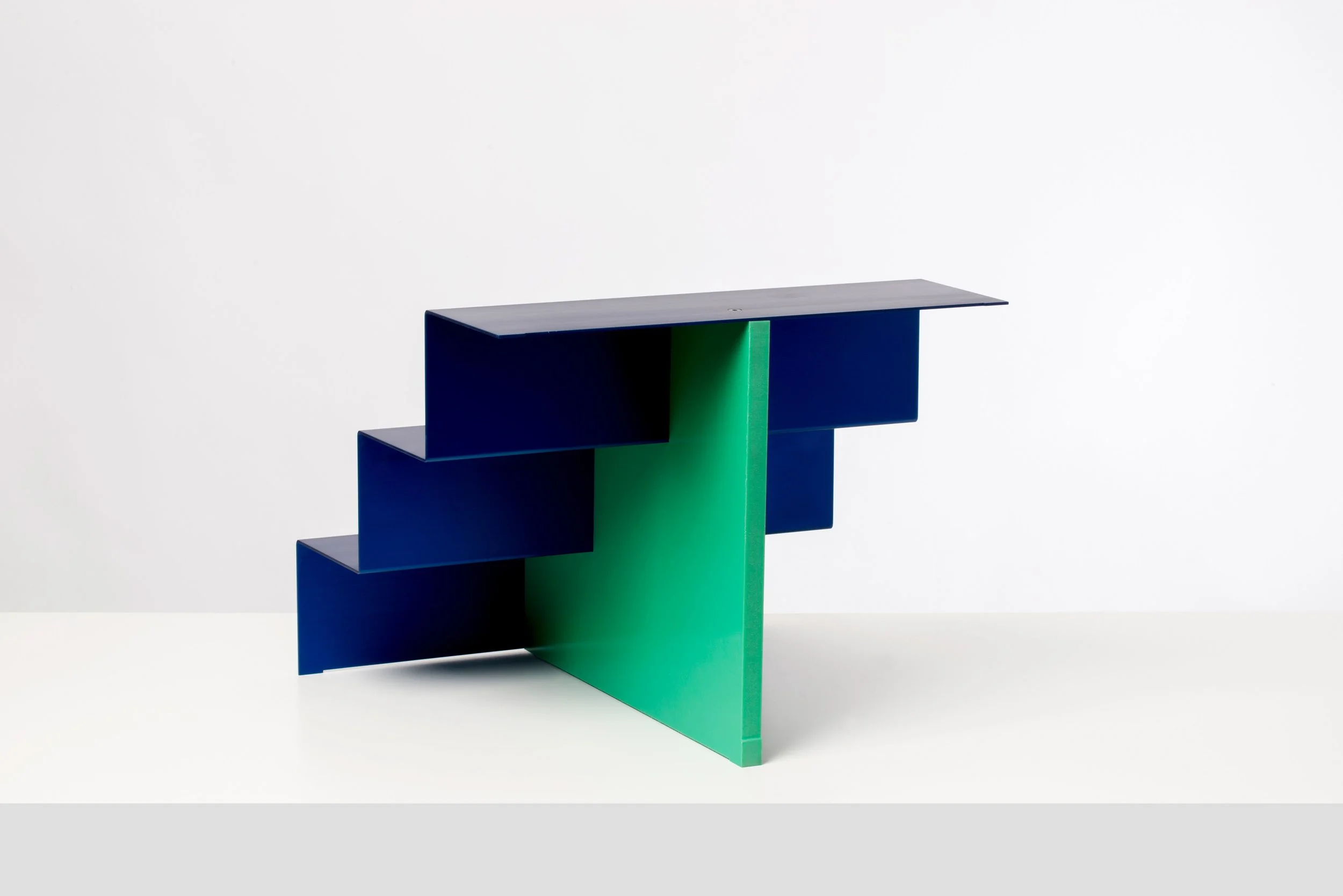 Modern piece of furniture with a green central support and blue horizontal elements, set against a white background.