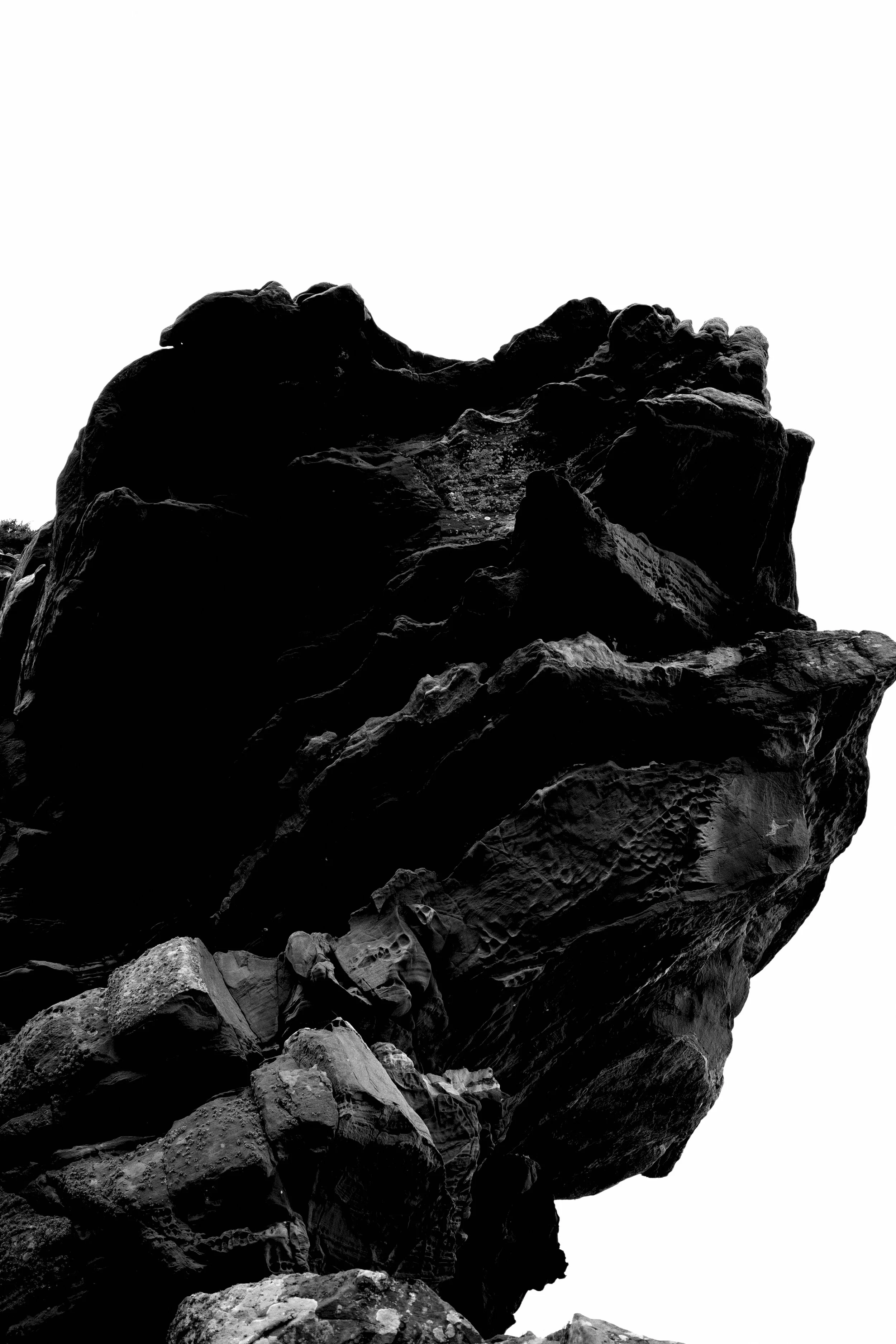 Close-up shot of large, rugged rocks or boulders with a high contrast black and white effect.