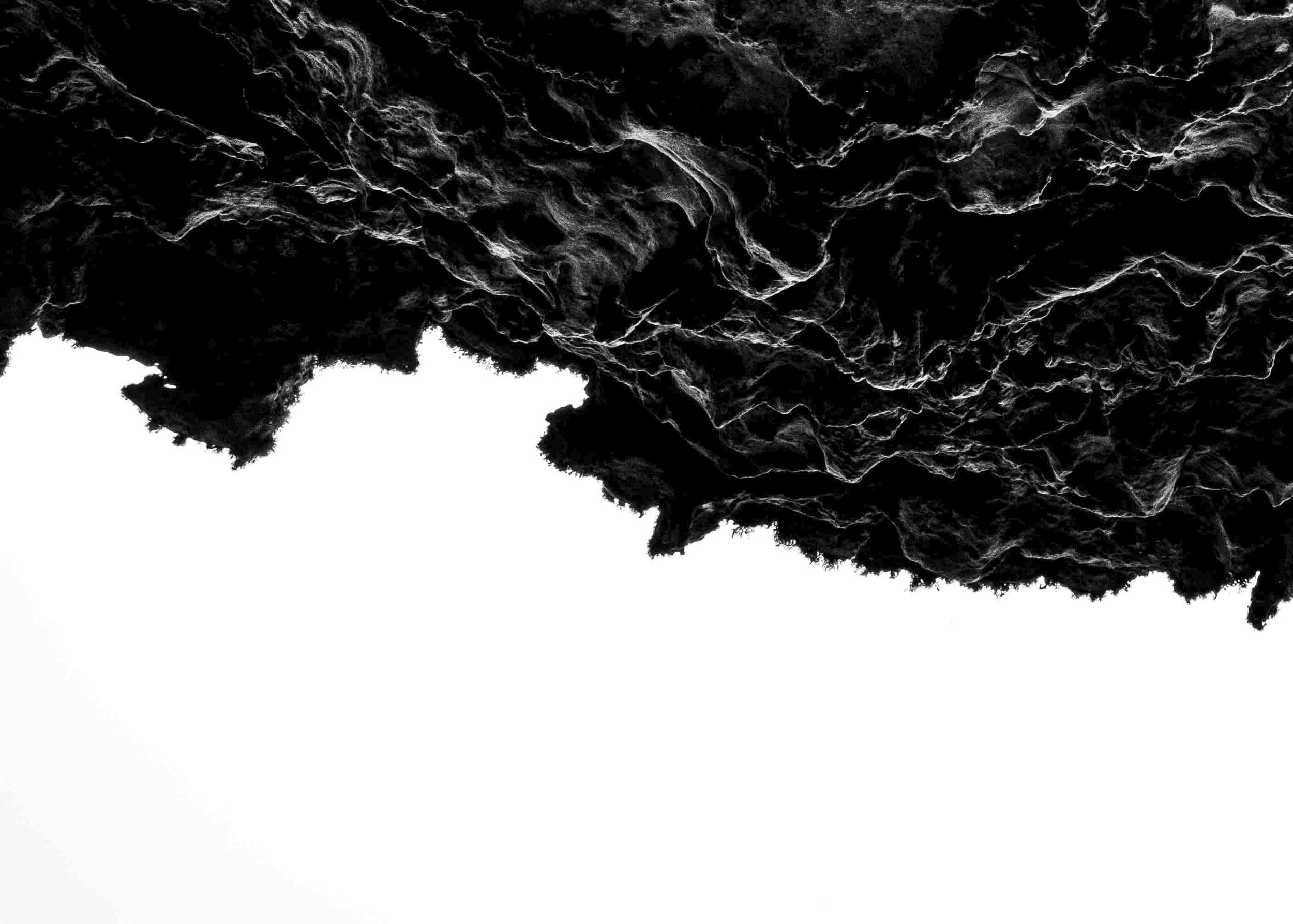 Black textured surface with rough, rocky appearance and irregular white patches.