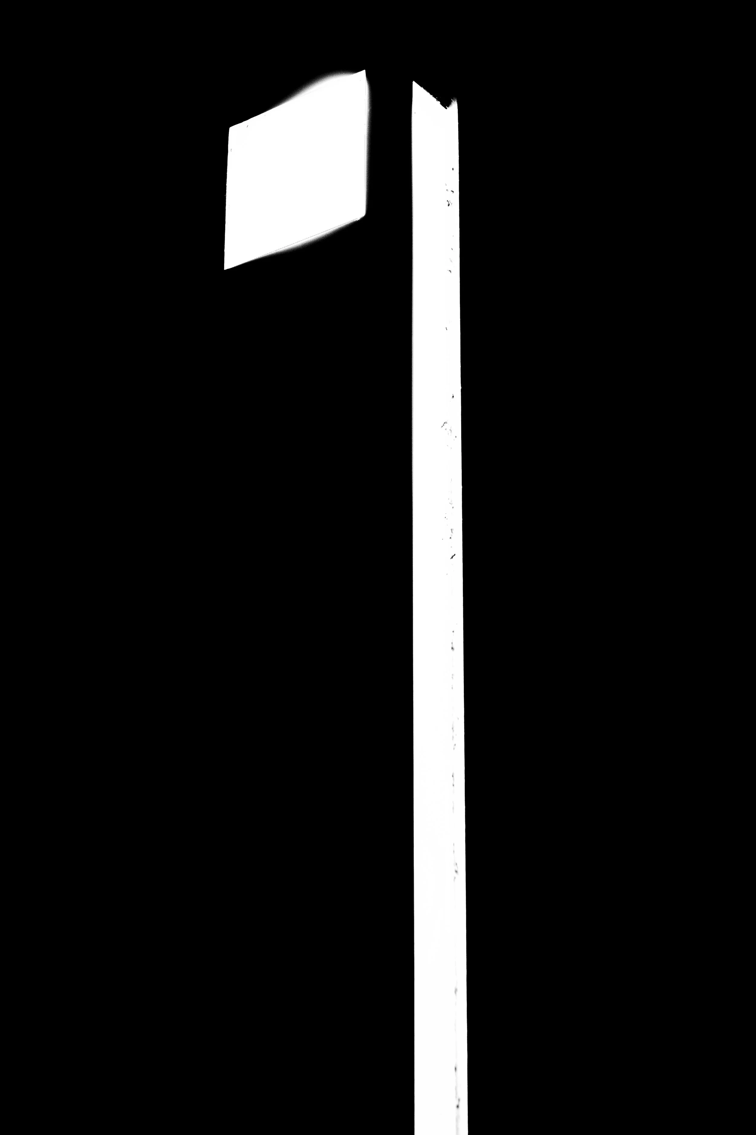 Silhouette of a streetlight against a dark sky.