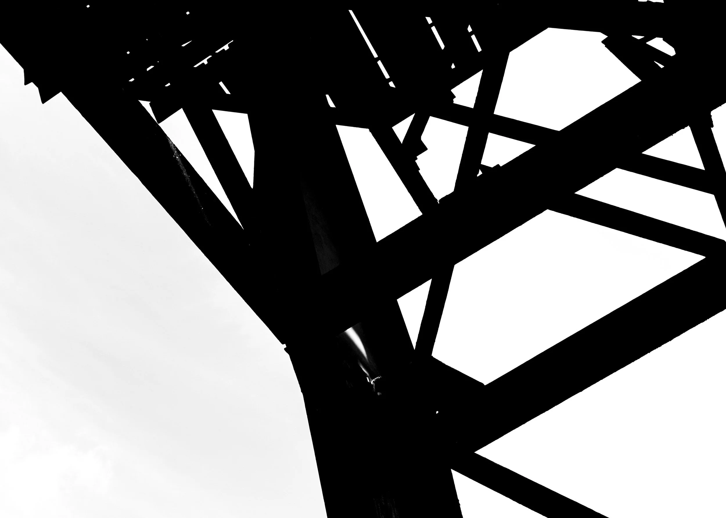 Silhouette of a metallic bridge or framework with geometric lines and angles in black and white.