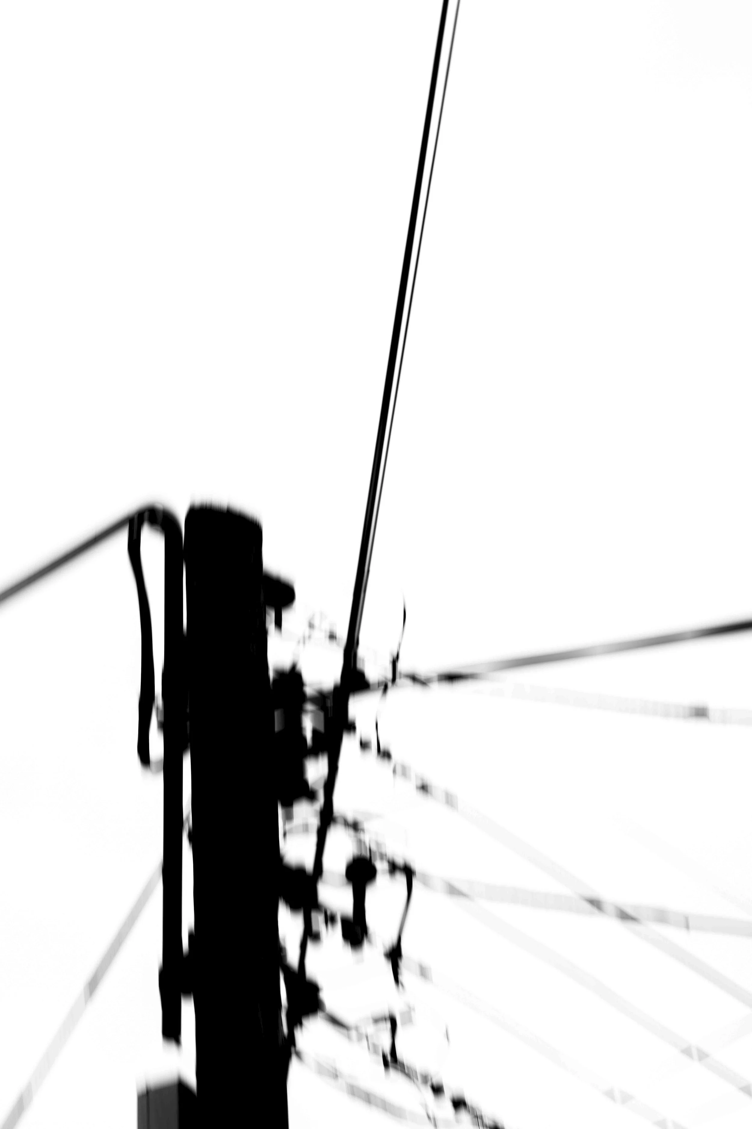 Black silhouette of utility poles with wires against a white background, with some additional lines extending outward.