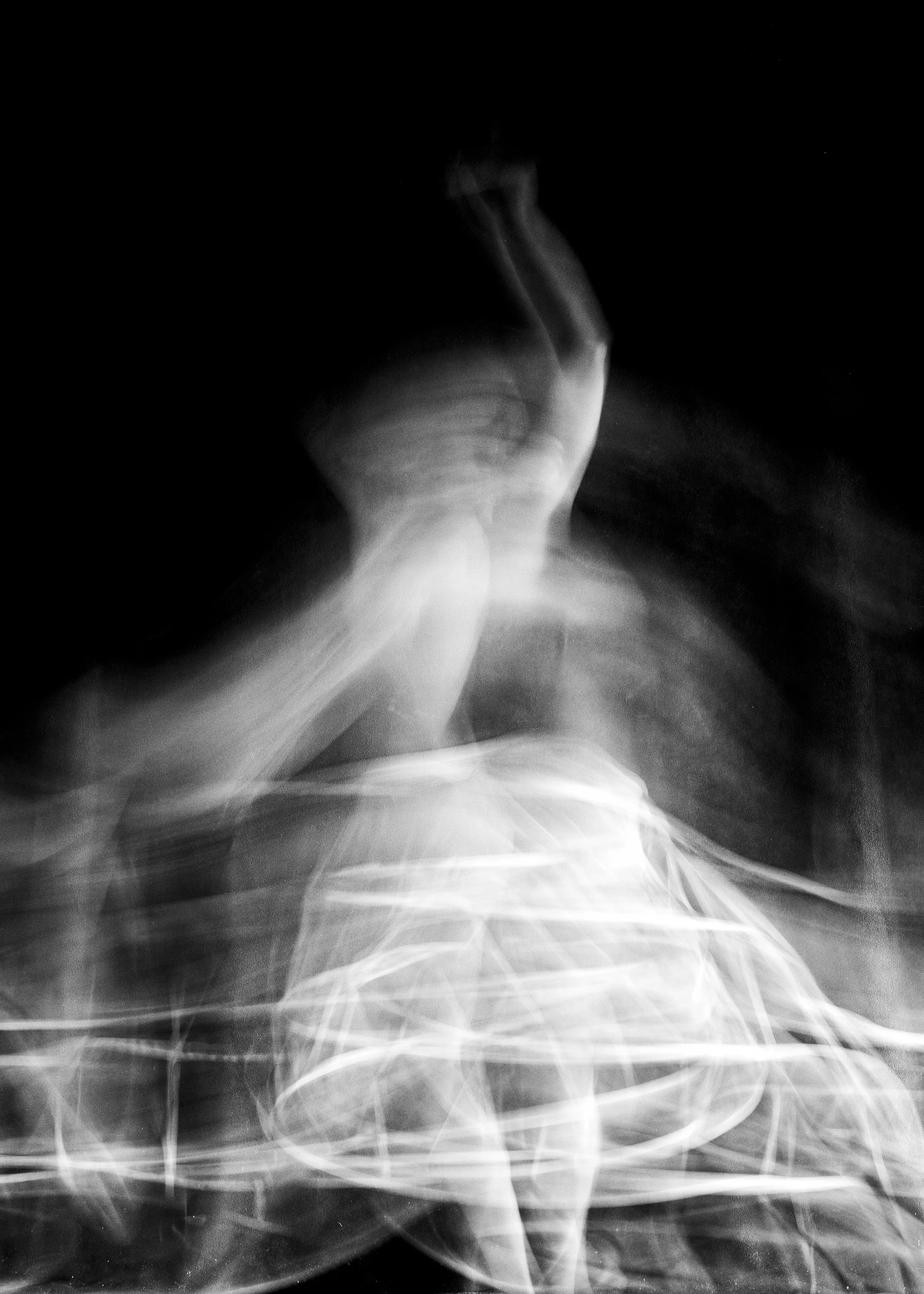 Black and white abstract photo of swirling person creating a sense of motion.