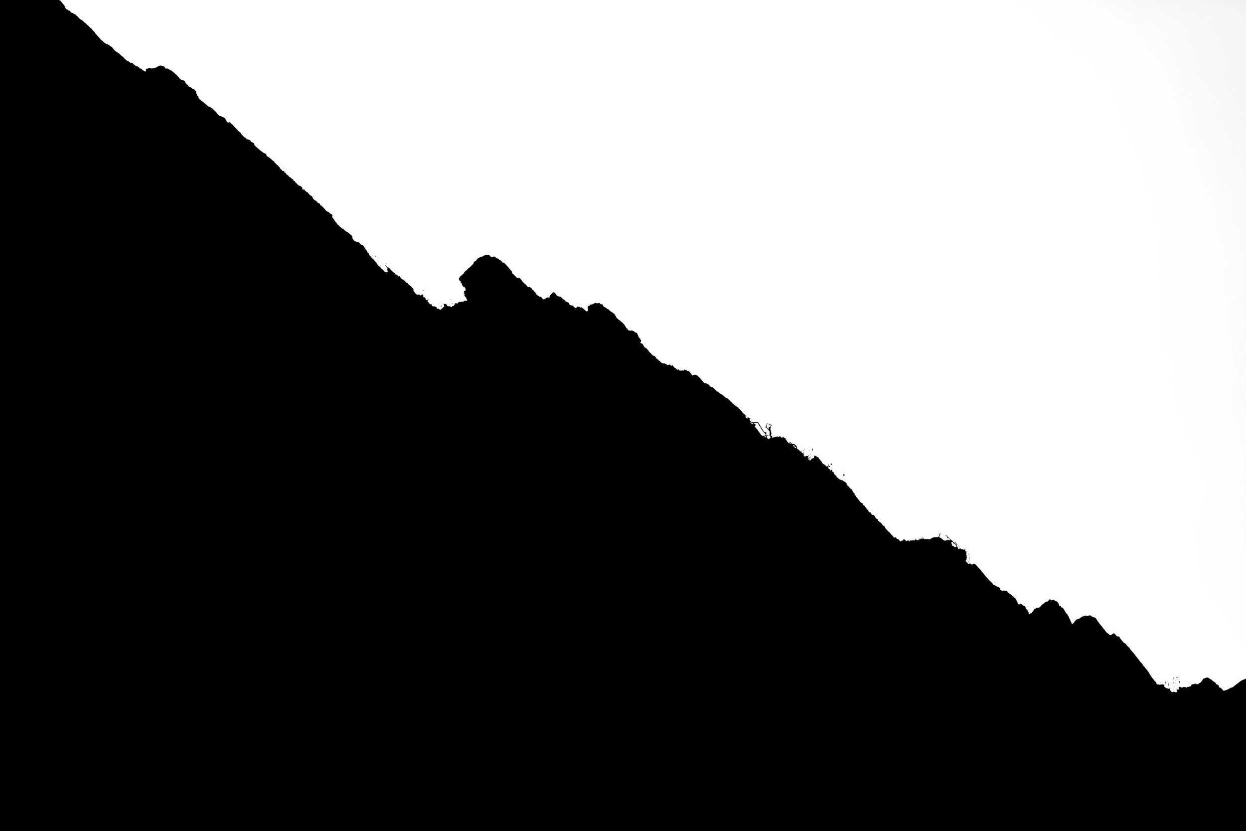 Silhouette of a mountain ridge with an astronaut standing on the crest