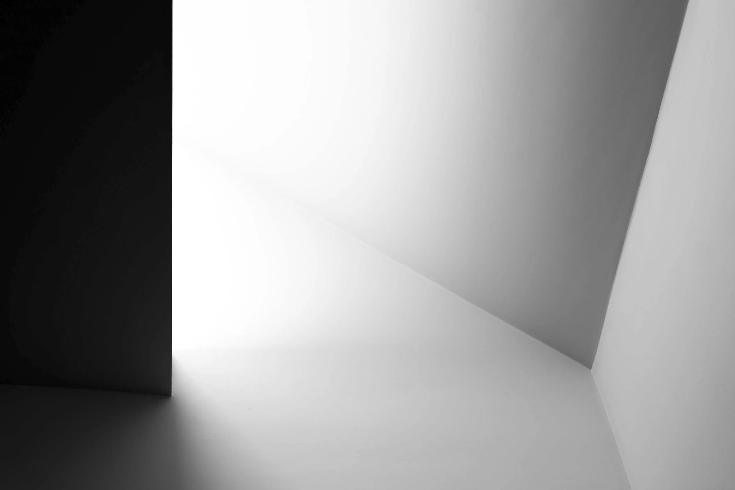 An abstract image with black, white, and gray geometric shapes and shadows.