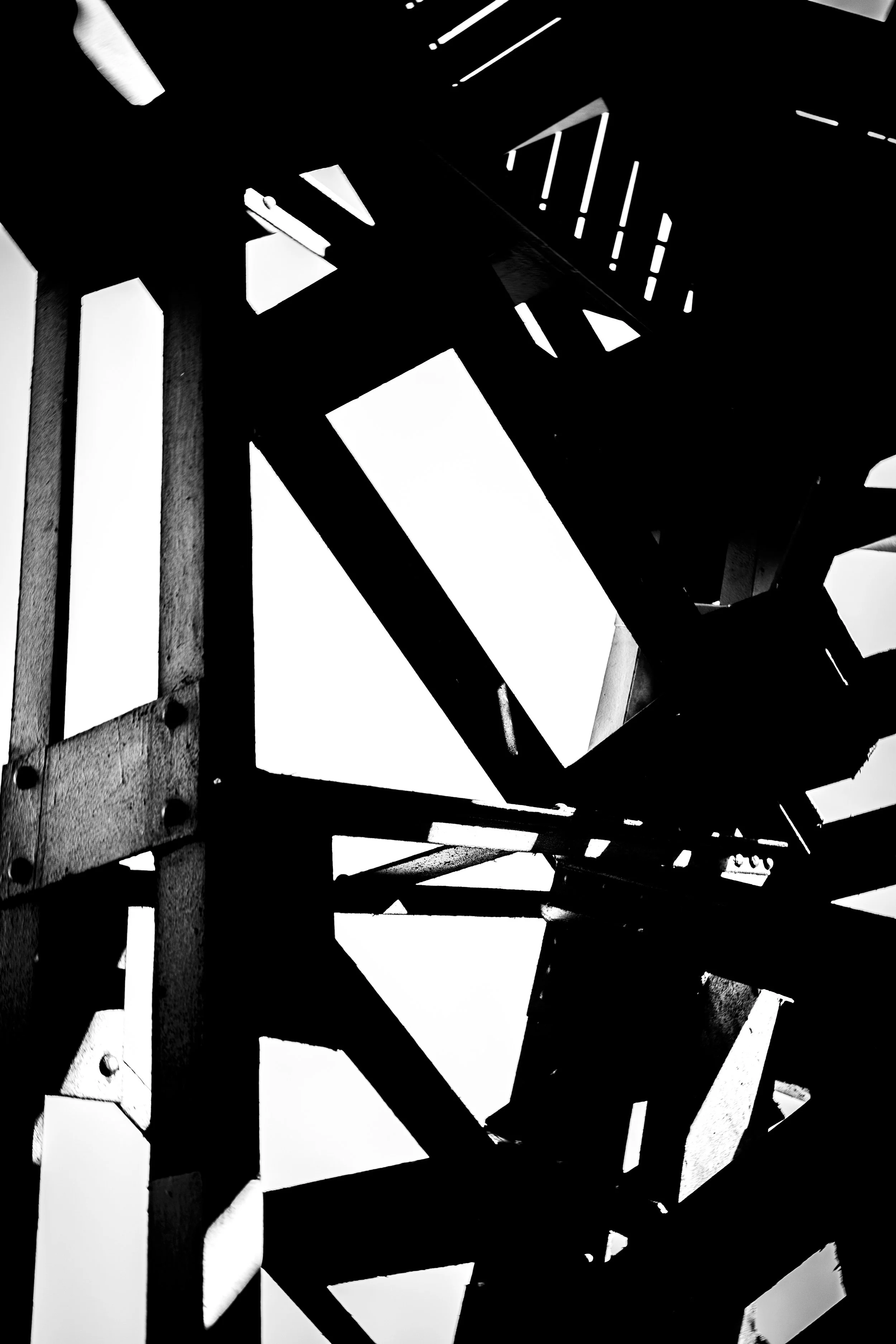 Abstract black and white image of geometric shapes and structure with contrasting light and shadows.